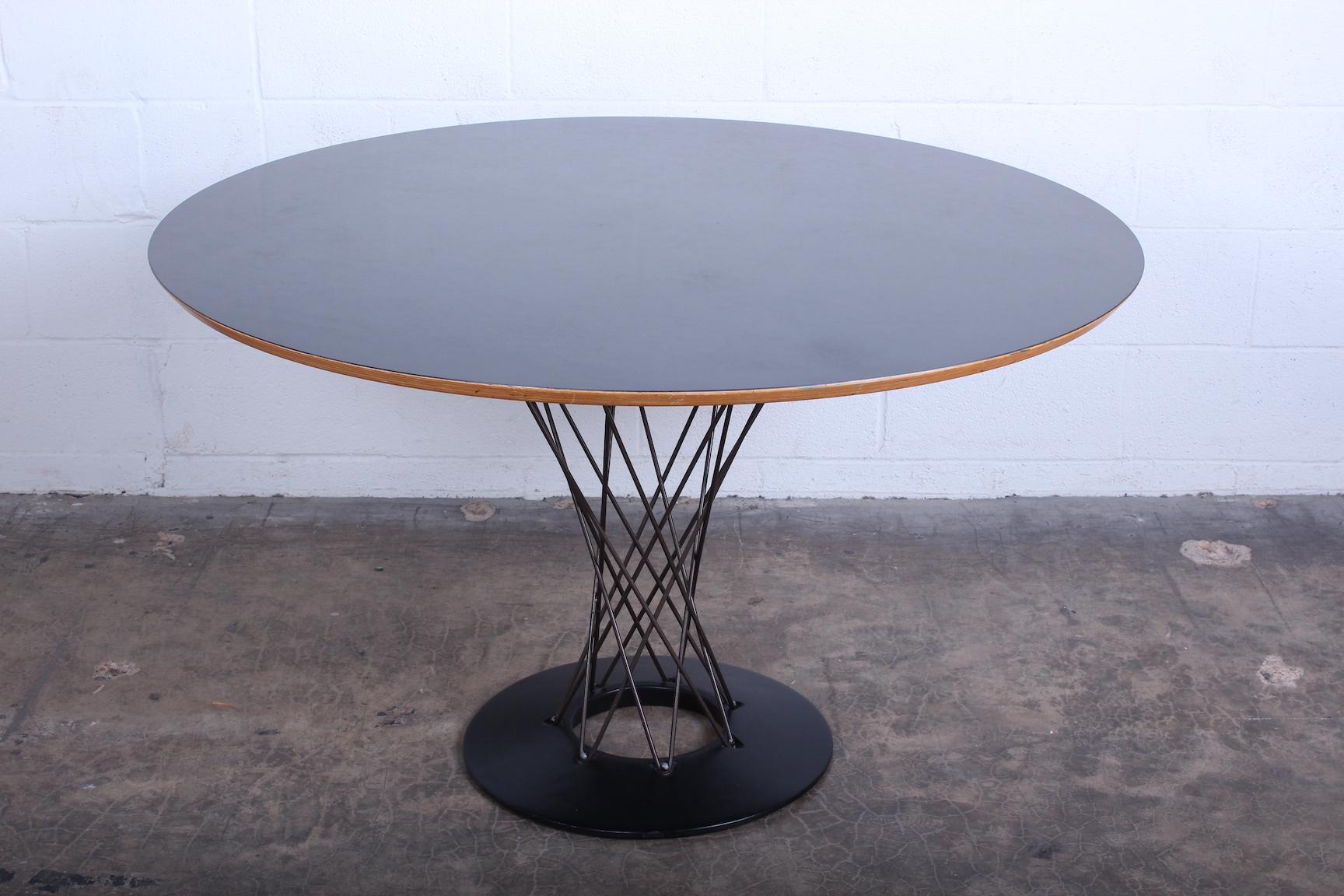 A cyclone table with black laminate top designed by Isamu Noguchi for Knoll.