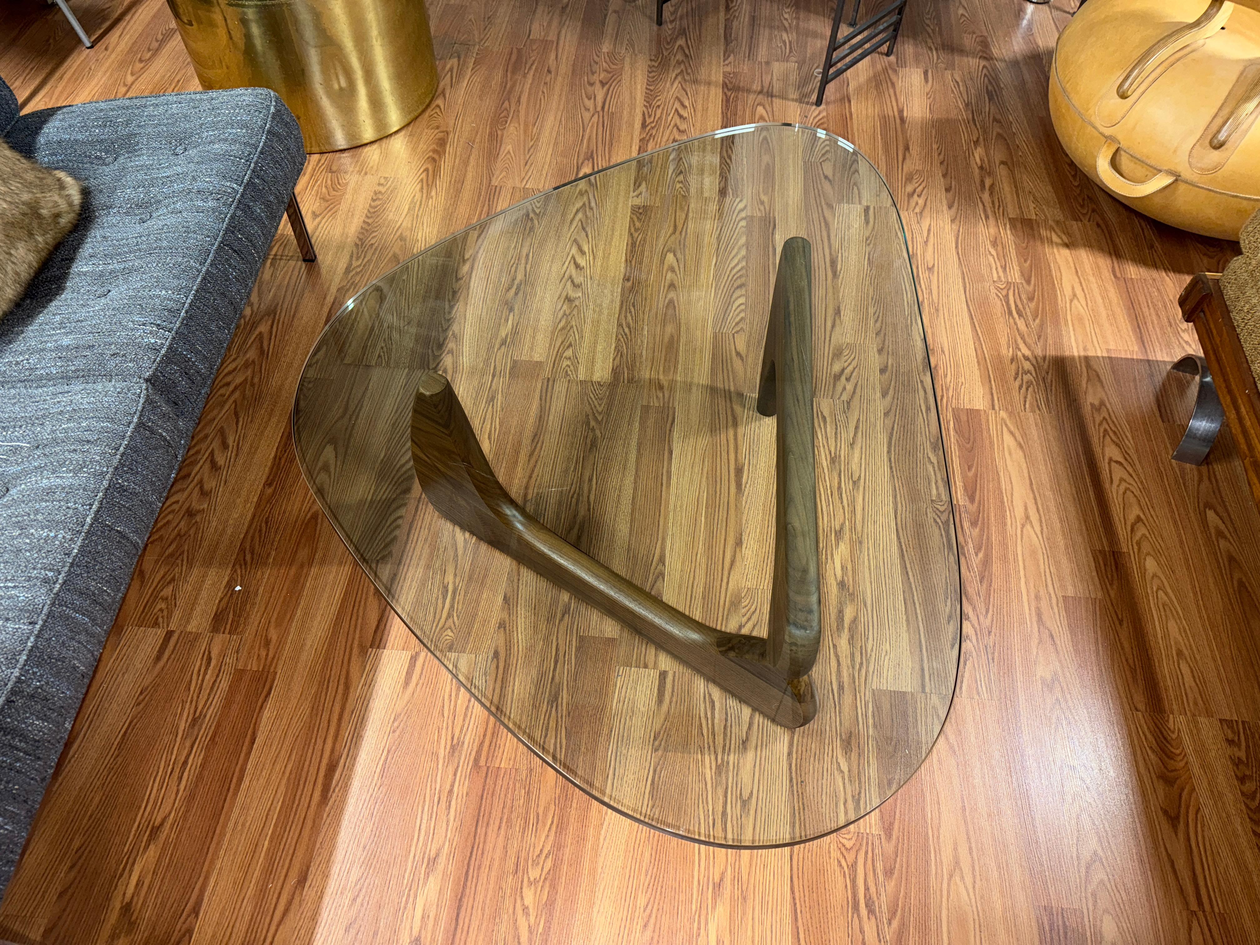A classic iconic table, this Isamu Noguchi design was used as a showroom sample for a retailer in the area.  It is the walnut version and features beautiful graining to the base and nice color.  The base has the Herman Miller label and the Glass top