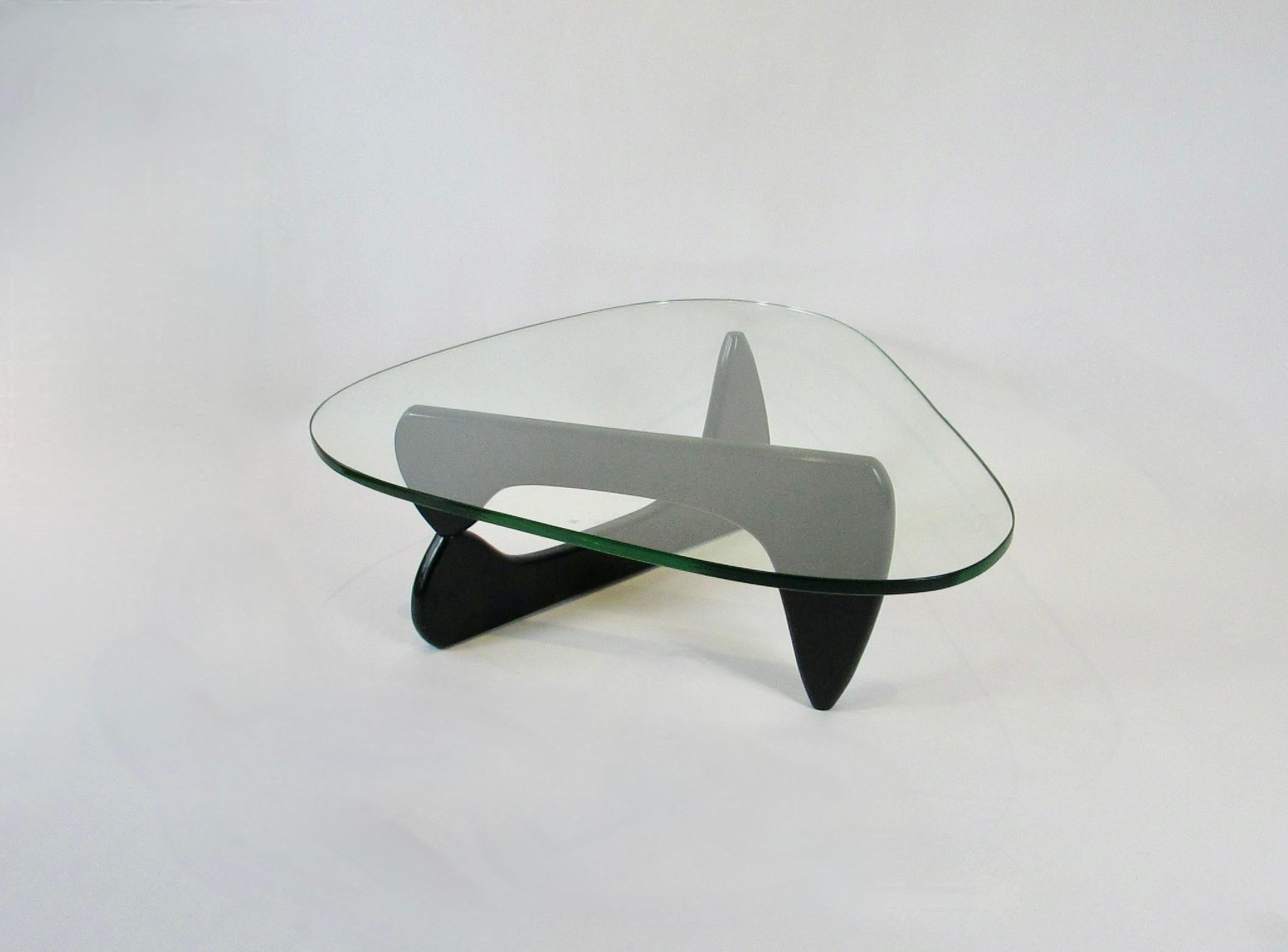Couchtisch, entworfen von dem amerikanischen Designer Isamu Noguchi (1904-1988) für Herman Miller. Dieser ikonische Tisch hat eine Basis aus zwei schwarz lackierten Massivholzskulpturen, die an einem versteckten Aluminiumstift aufgehängt sind. 3/4
