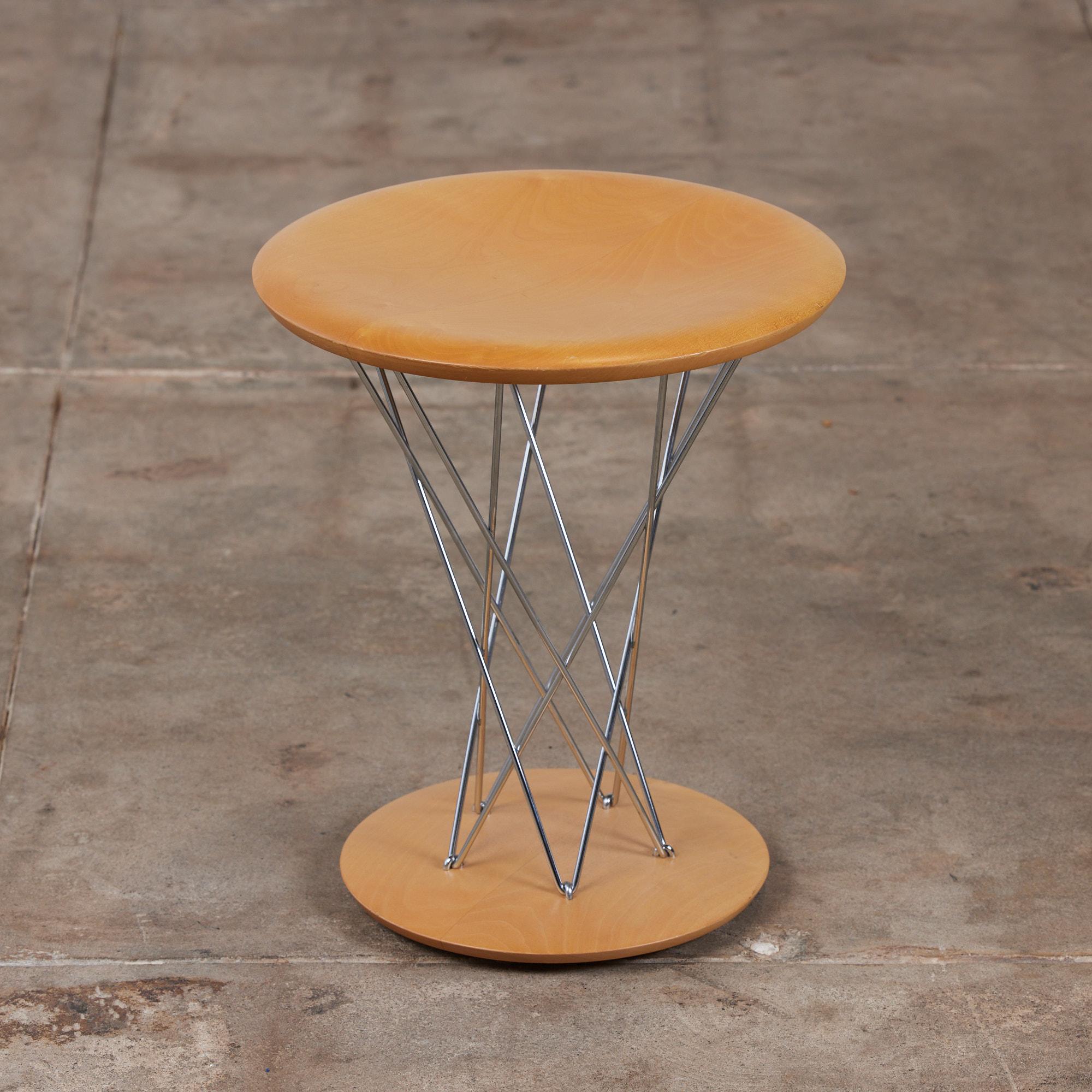 Isamu Noguchi rocking stool, originally designed in 1954 this example was reissued in 2001 for Vitra. This stool features a maple seat and base with steel chrome plated rods connecting the two pieces giving it its nickname, 