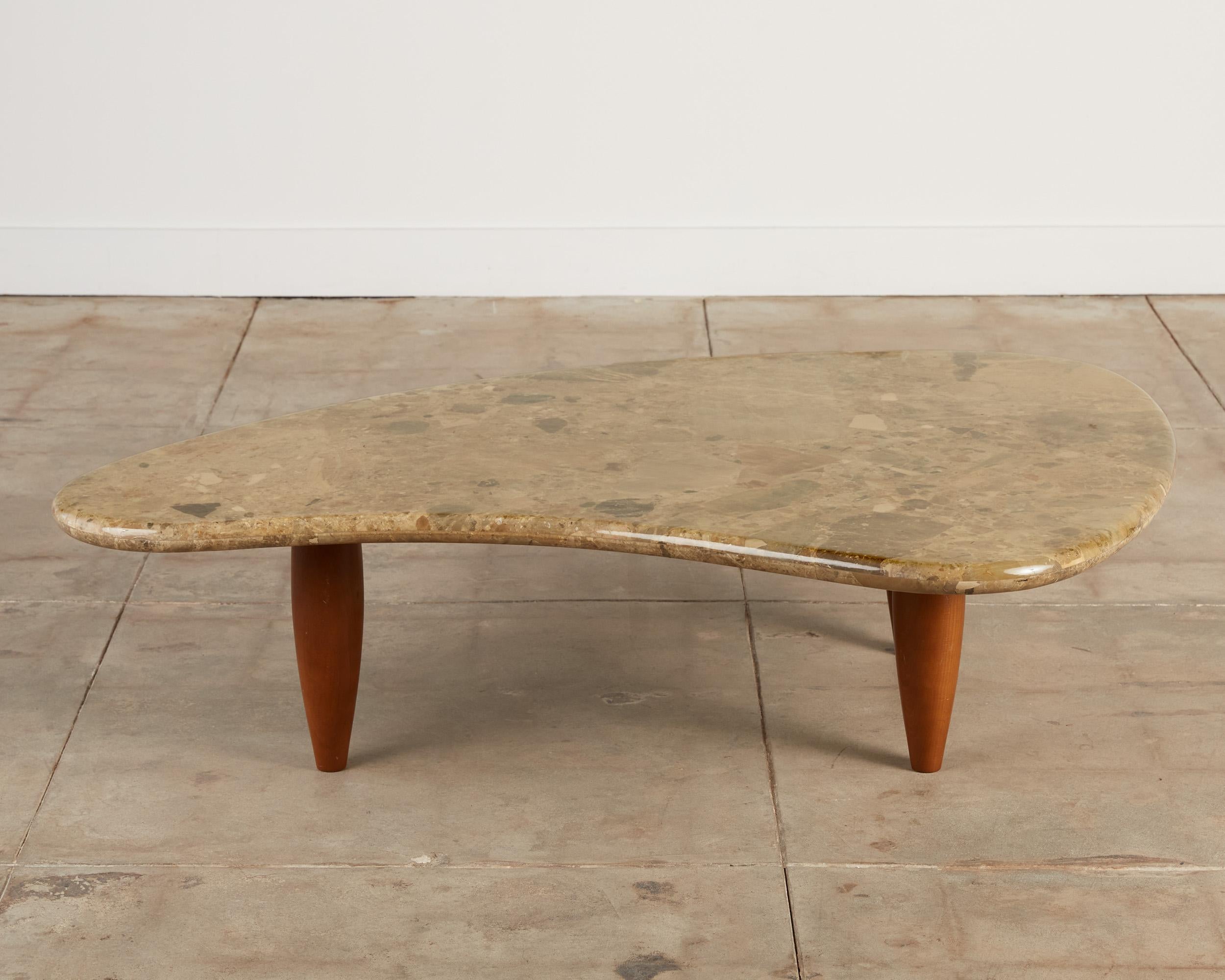 Isamu Noguchi style coffee table features a sand-colored marble top with a speckled grain and rounded edges. The base consists of tapered turned walnut legs. Its captivating form and presence ensures this piece elevates any space it goes in.