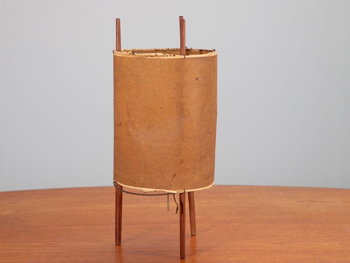 Scarce model 9 three-legged cylinder table lantern, designed by Isamu Noguchi. A pared down design, consists of aged fiberglass shade supported by three cherry legs. 1950s.

Measures: 16” Tall × 8” wide.