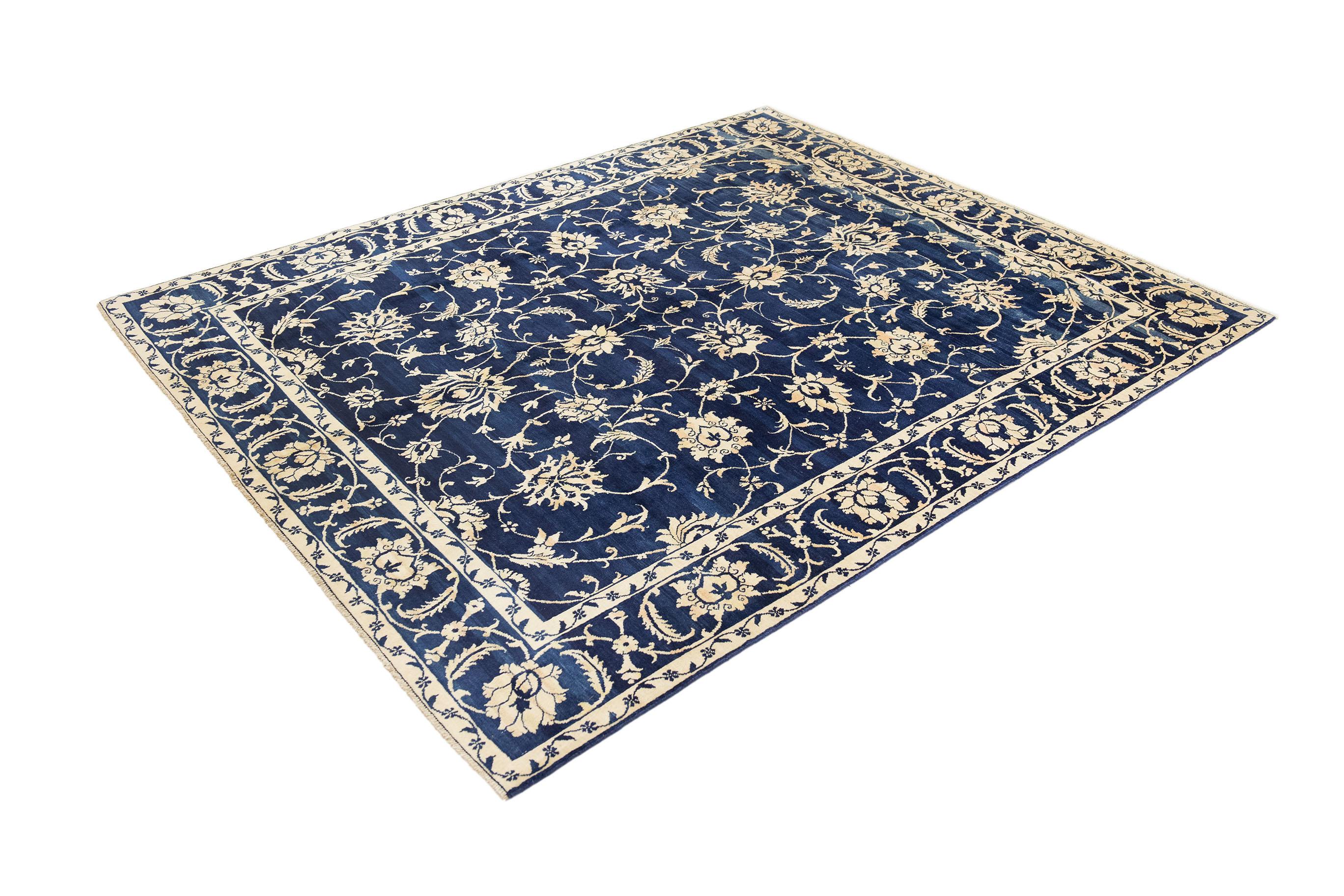Tapis d'Ispahan noué à la main, fabriqué en Iran vers 1990.

Elegant champ bleu foncé avec des motifs floraux ivoire contrastés, mettant en valeur l'art persan classique.

Poil de laine sur chaîne de coton, alliant durabilité et texture douce et