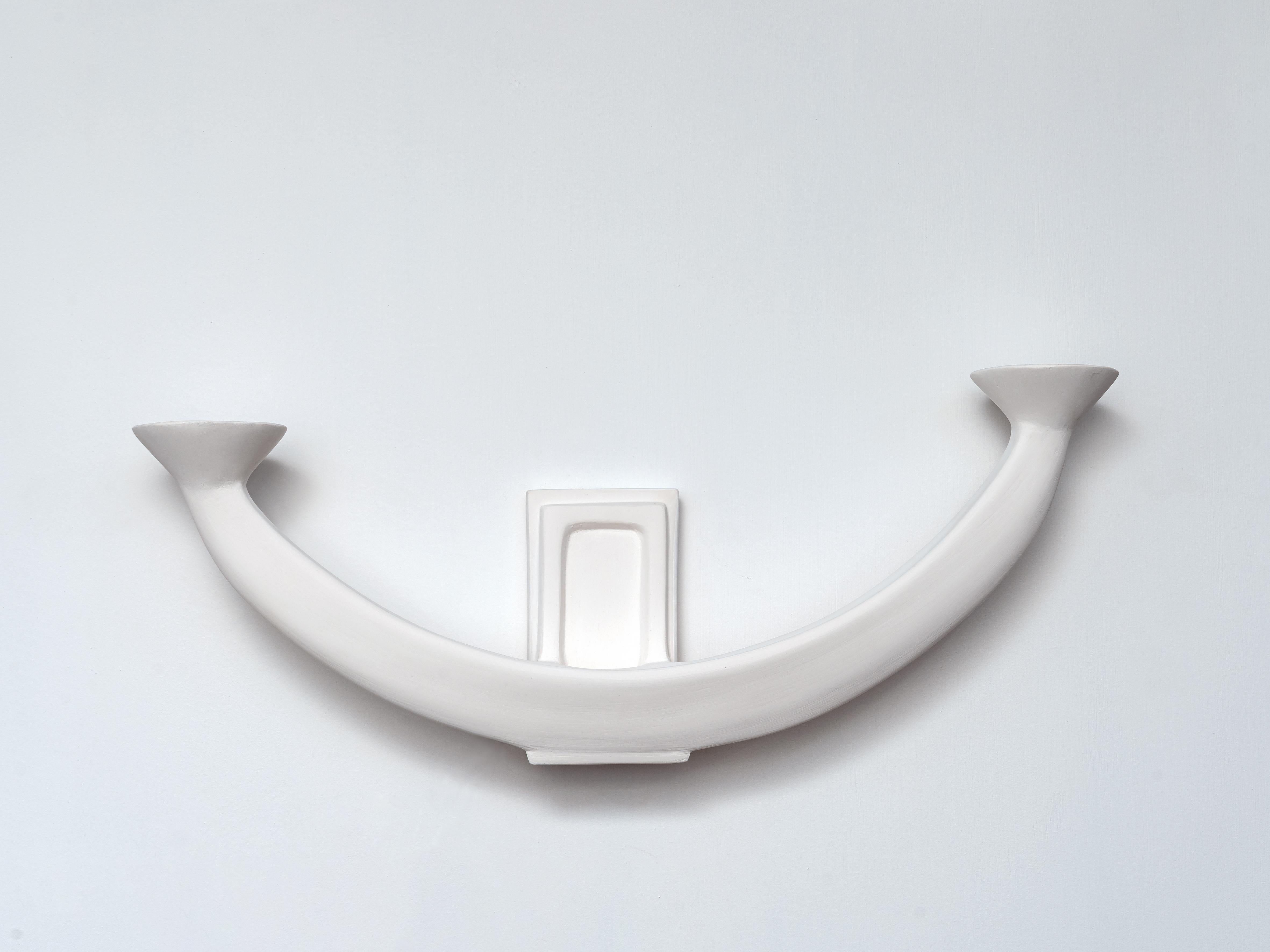 The 'Isis' wall sconce by Benediko is a captivating fusion of contemporary design and ancient symbolism. Inspired by the sacred boat of the Egyptian goddess Isis, this piece embodies both elegance and mystique. Handcrafted from white plaster over a