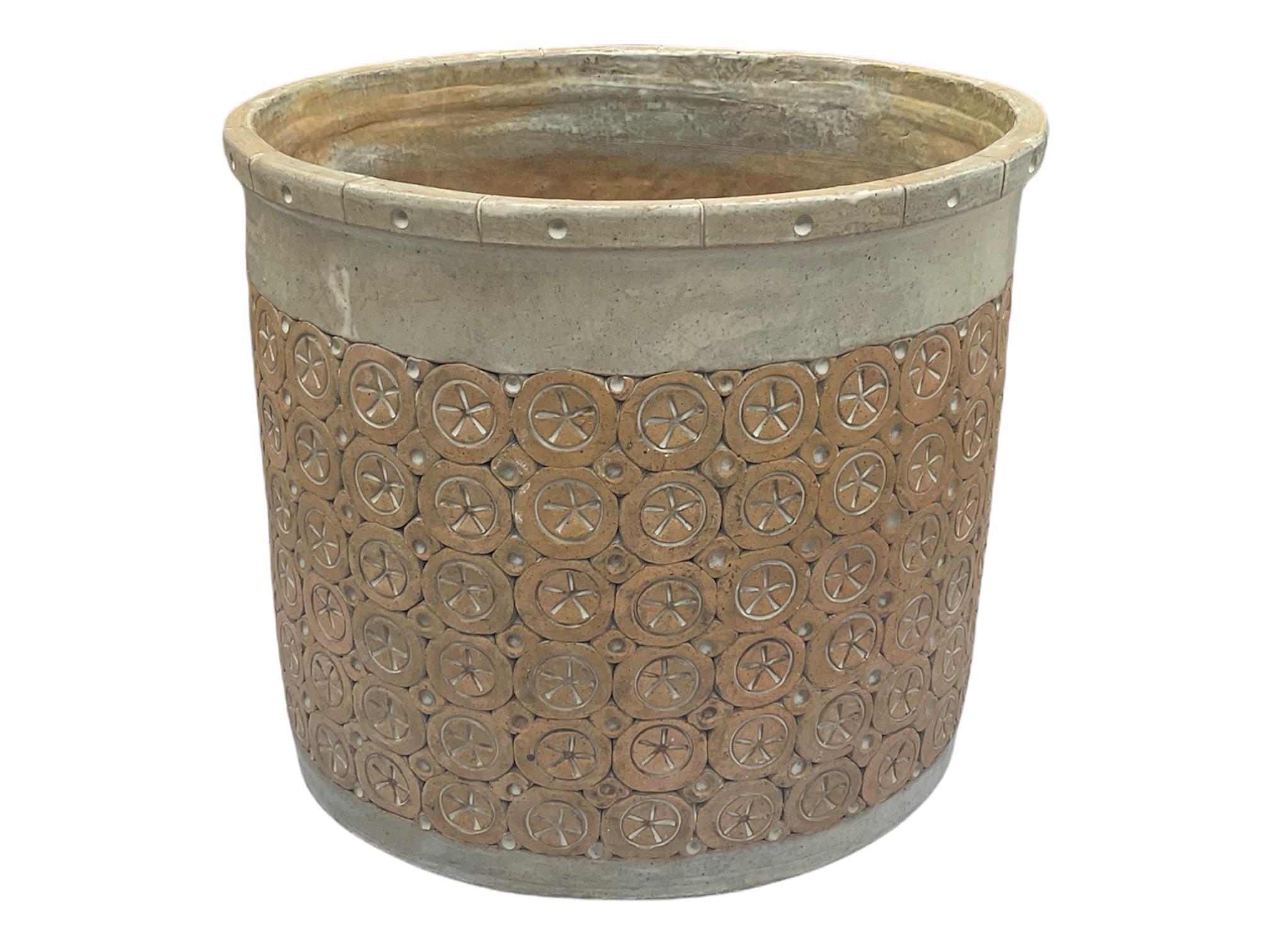 This is an Isla Del Sol Puertorican large and heavy stoneware round planter. It is decorated with six rows of circles adorned with stars in the center alternated with five rows of small circles. It weights 75 pounds.