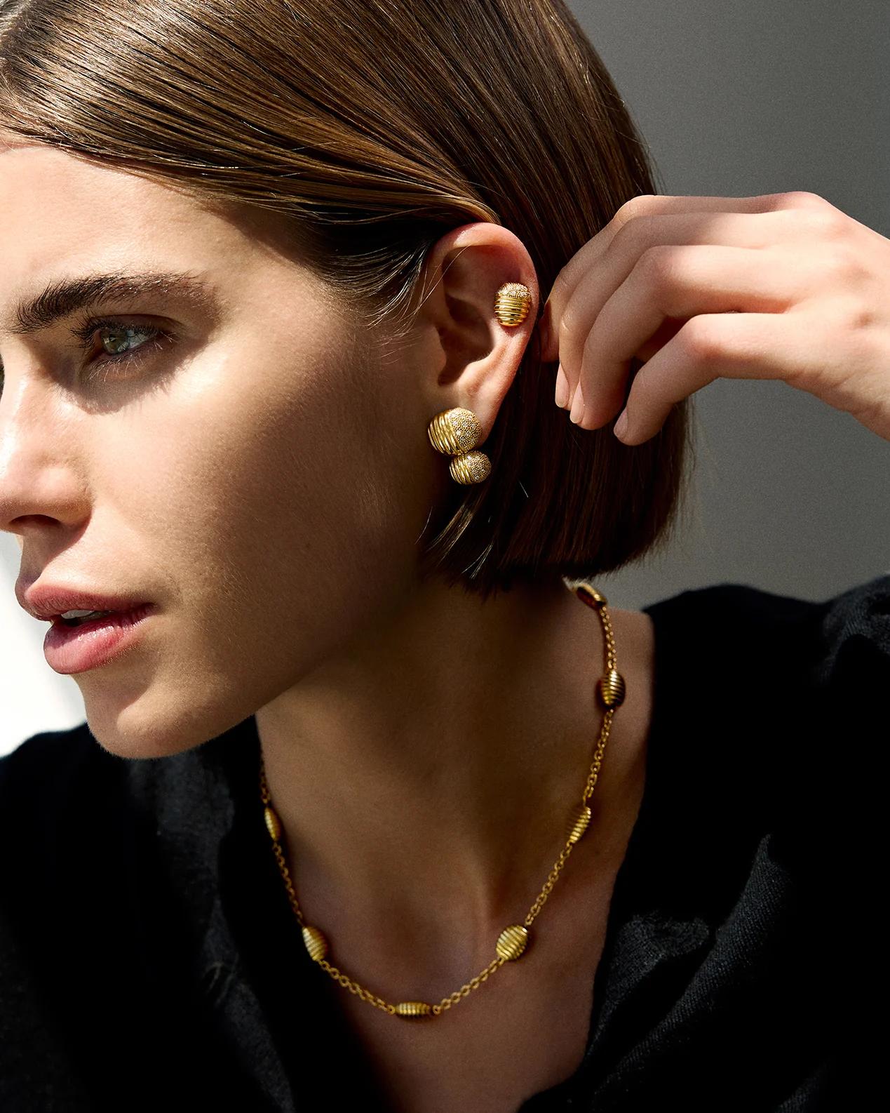 Isla brings form to Pamela’s love of working with texture and shape. A gleaming finish of polished ridges and sandblasted channels evokes both the nobility of ancient worlds and the glamour of the 70’s.

Hand-finished 18k gold, 10.56g, 0.68ct