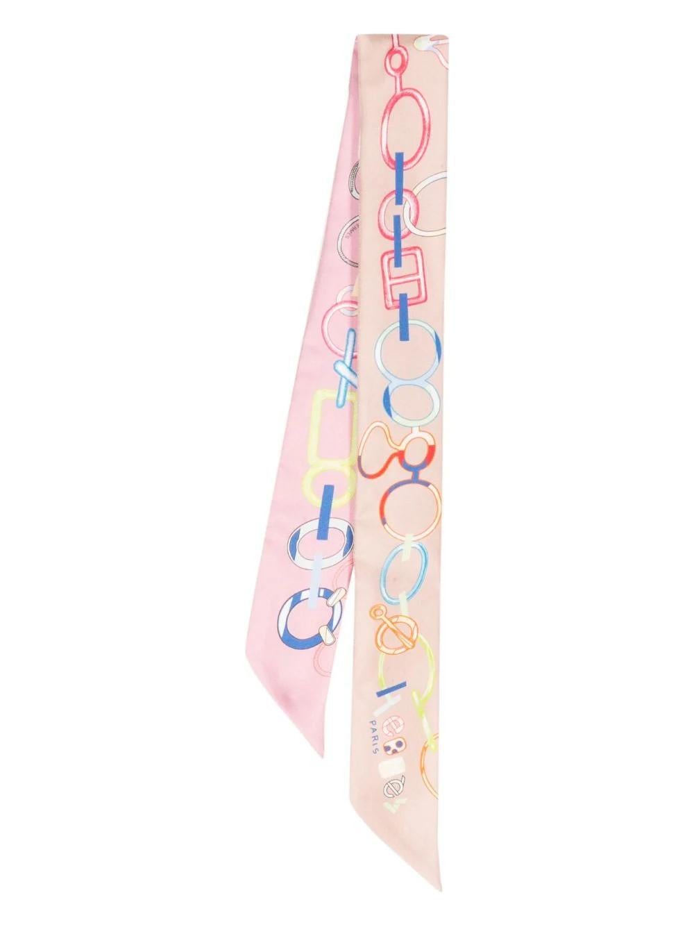 A perfect accessory for any look, the Isola di Primavera Silk Twilly Scarf adds a subtle pop of colour. This light pink, silk scarf features a skinny design, buckle print, and finished edge. Style as a hair accessory or tie to your favourite