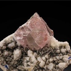 Cristallo isolato di fluorite rosa su albite e muscovite dal Pakistan
