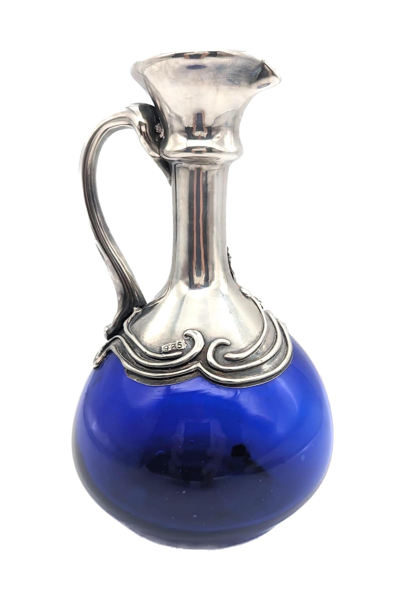 In offerta c'è una caraffa artigianale in vetro soffiato blu cobalto e argento sterling realizzata in Israel all'incirca tra i primi e la metà degli anni Settanta. 

Misura 5,25
