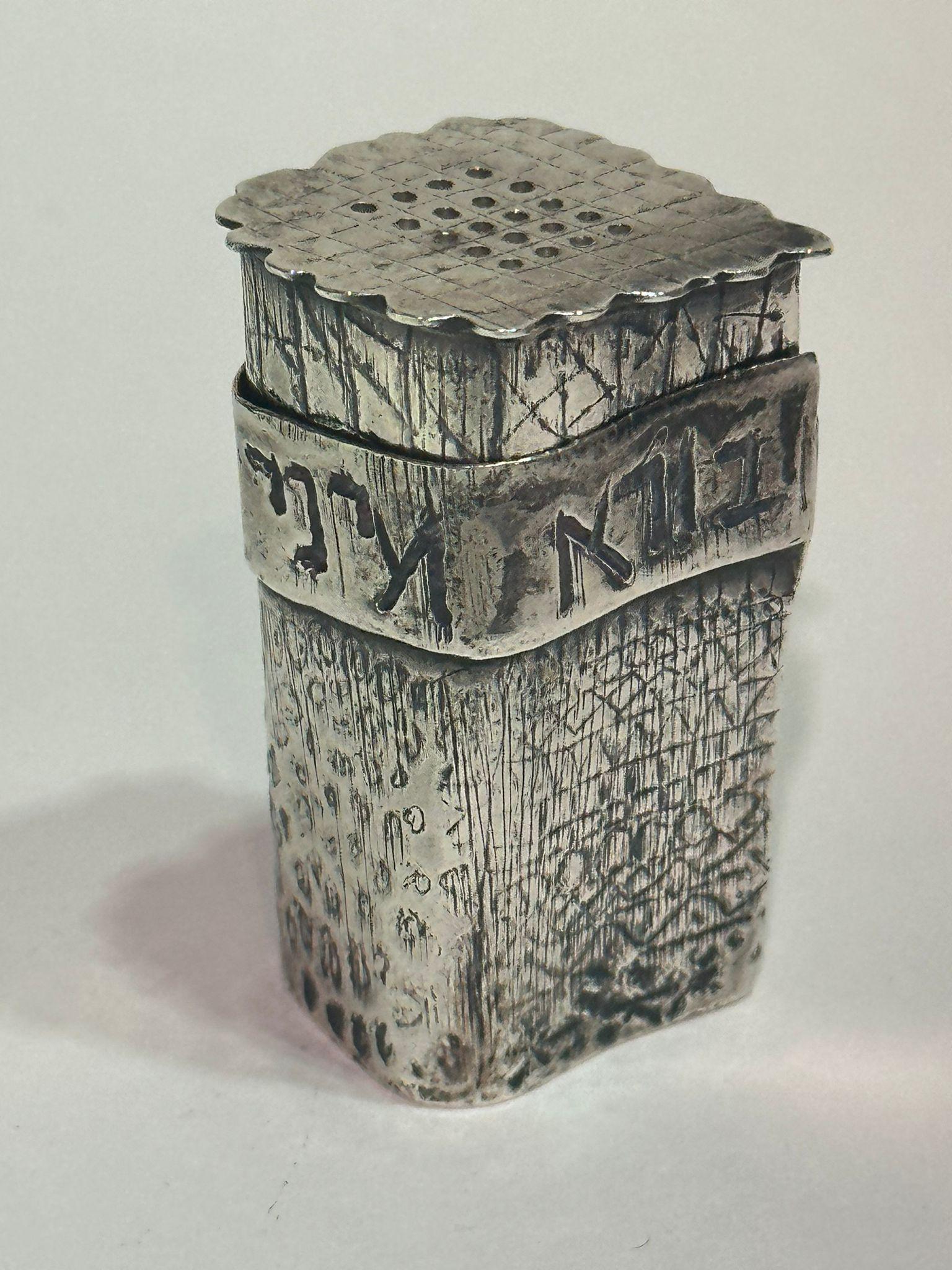 Cette boîte à épices israélienne en argent de la fin du XXe siècle présente une esthétique artisanale réalisée par un orfèvre local, bien que la signature du fabricant sur la base soit partiellement illisible. La forme rectangulaire, dont la texture