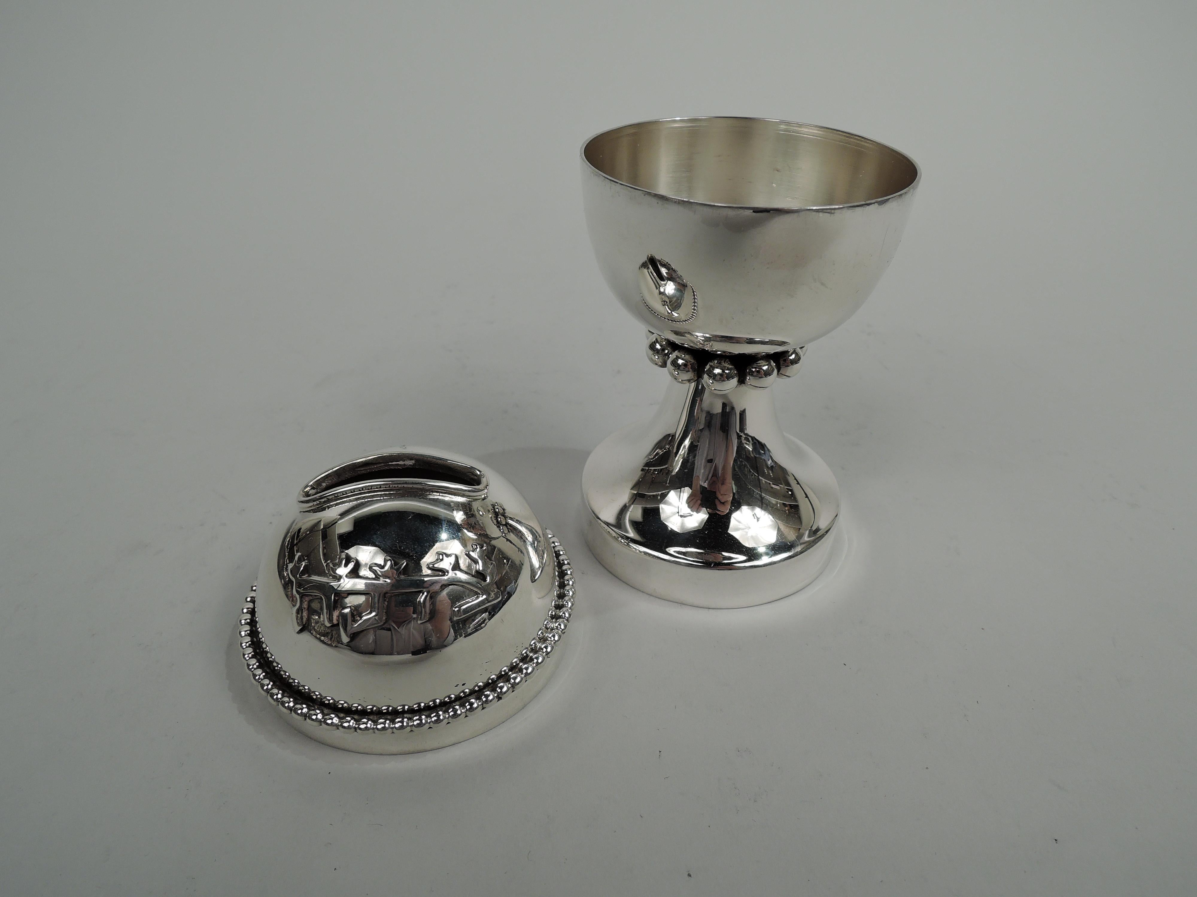 Modern sterling silver tzedakah box. Globular bowl with wide slot for inserting the big coins; raised and round foot. Beading. Applied Hebrew letters. Marked “925 / Israel / Ber”. Weight: 5 troy ounces.