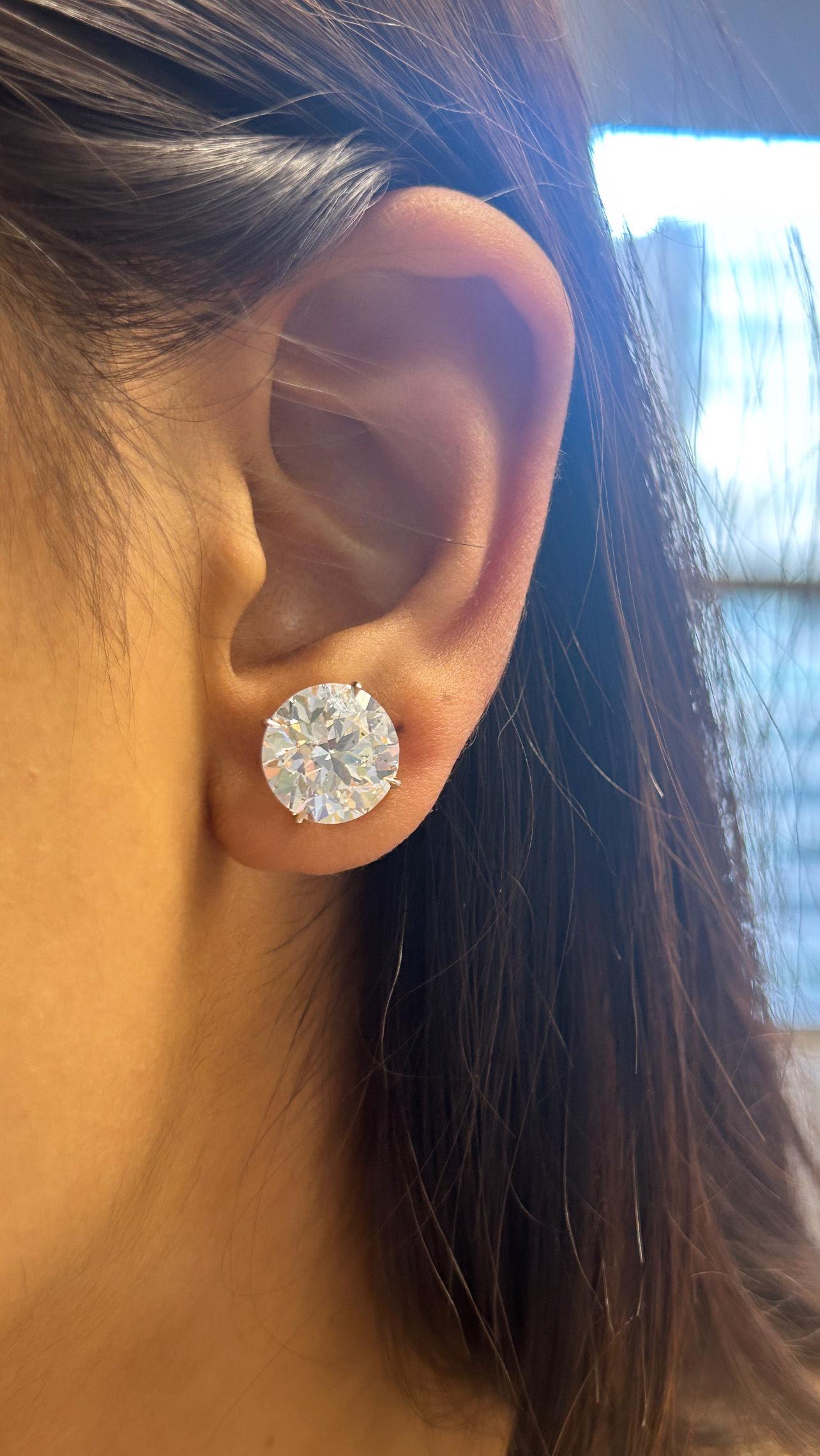 These Issac Nussbaum magnificent natural round diamond earrings are a true statement of luxury, featuring an impressive total carat weight of 12.23 carats. Perfectly matched for brilliance and balance, these diamonds exemplify the pinnacle of fine