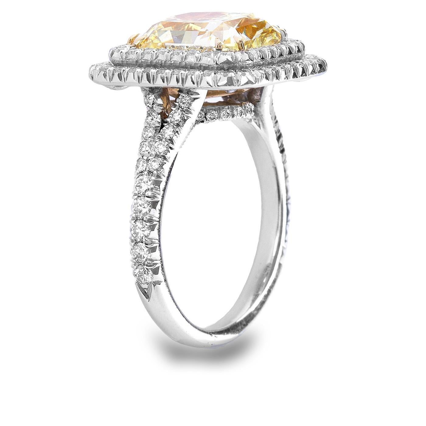 Impressive is just one of the many attributes of this double halo Ring.
GIA Certified 4.68 carat fancy Yellow Radiant cut Diamond. 
Graded by the GIA VVS2 in clarity, the sun like color center stone is set in a magnificent double halo with round
