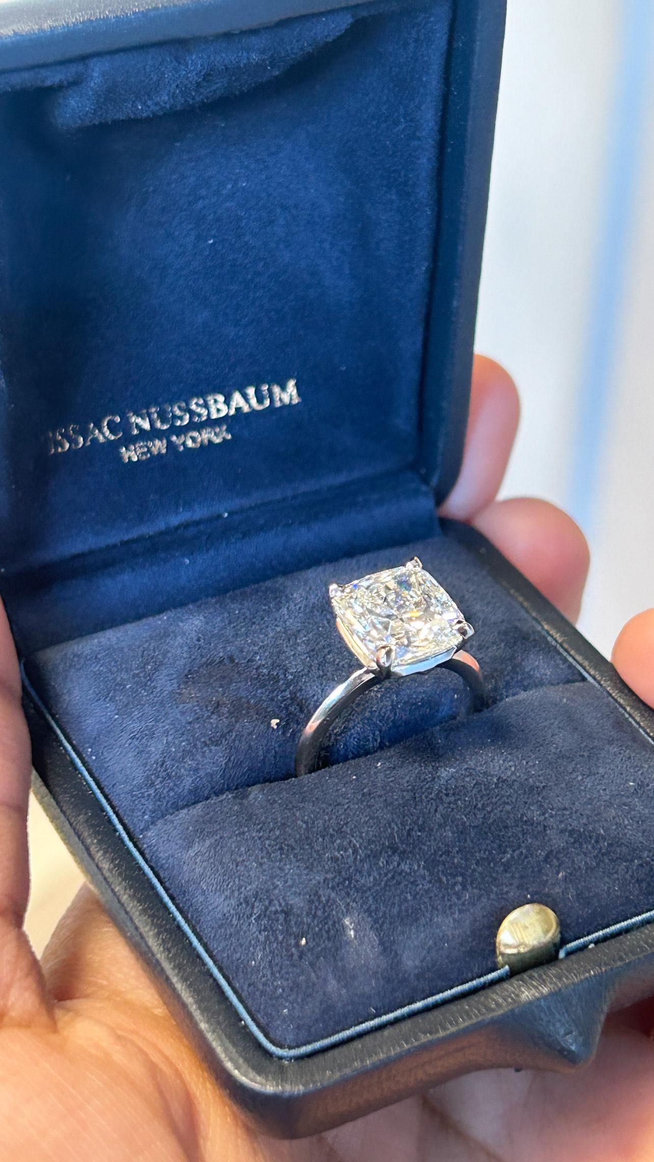 This stunning Gia-certified platinum ring features a remarkable 5.02-carat cushion diamond, a true embodiment of elegance and luxury. The cushion cut, with its rounded corners and larger facets, allows for exceptional brilliance and fire, creating a
