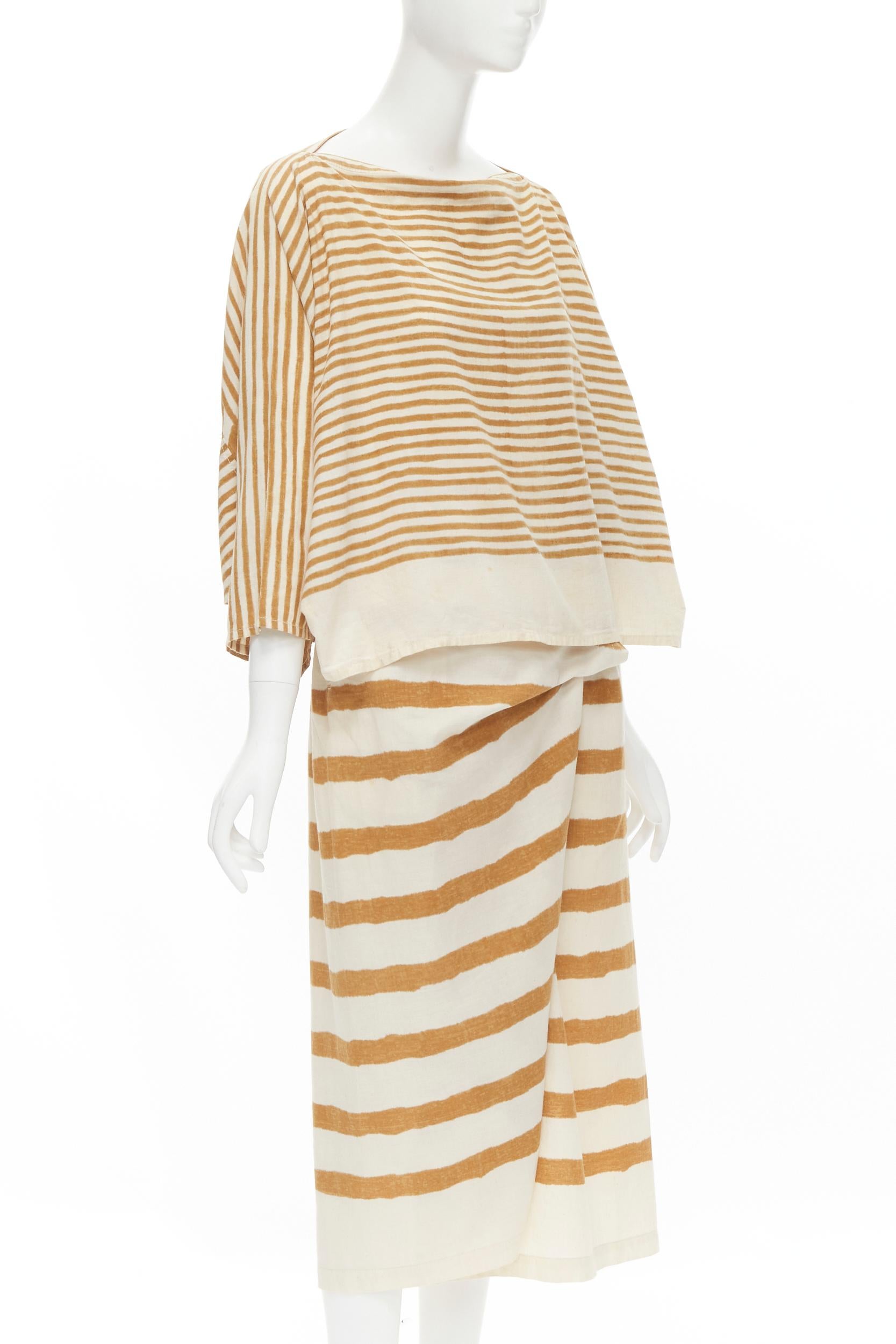 ISSEY MIYAKE 1980's Vintage beige yellow tribal stripe boxy top skirt set 
Reference: CRTI/A00505 
Brand: Issey Miyake 
Collection: 1980's 
Material: Cotton 
Color: Beige 
Pattern: Striped 
Closure: Button 
Extra Detail: Boat neck. Dolman sleeves.