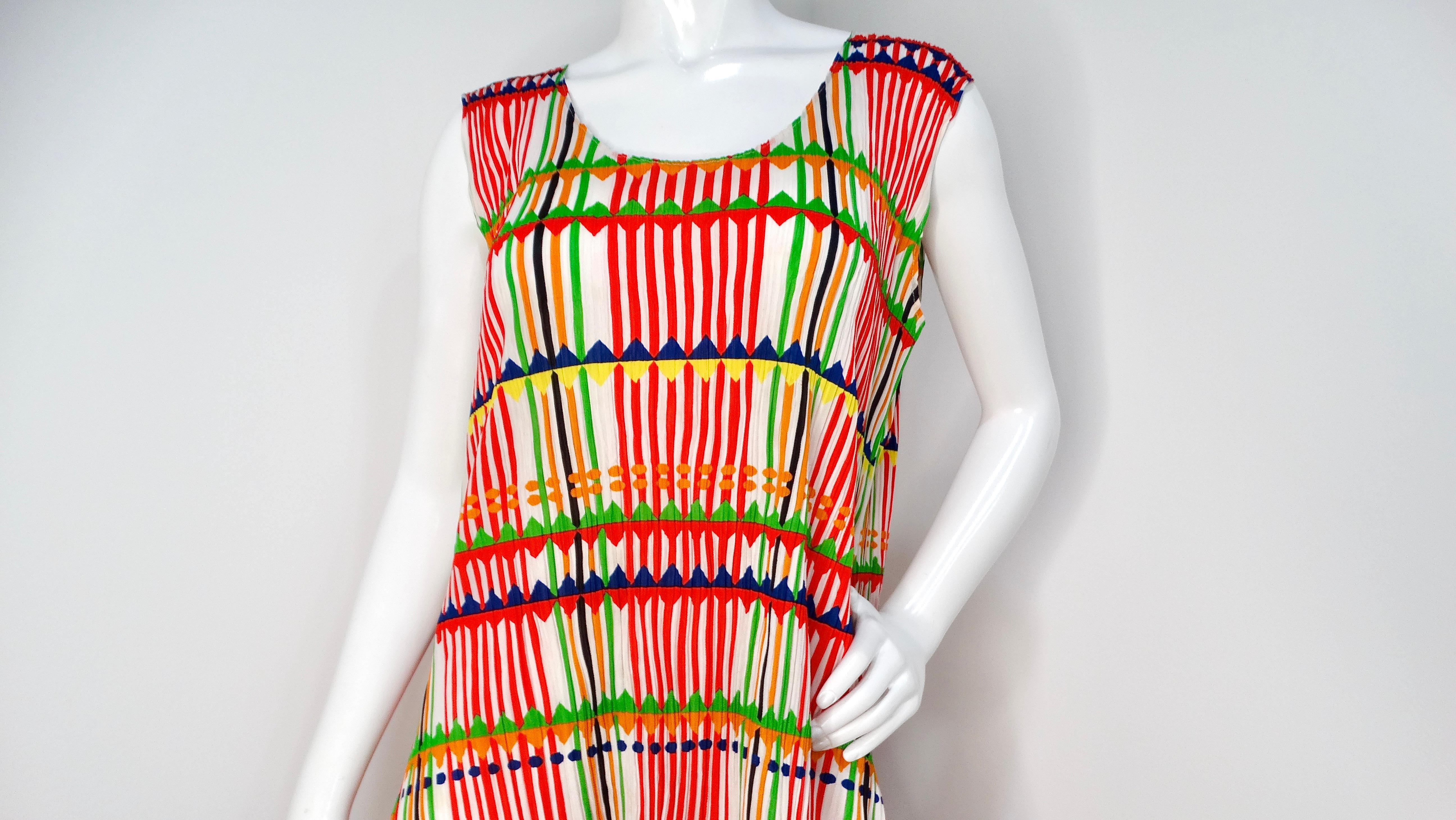The Issey Miyake 1990s Pleats Please Multicolor Pleated Maxi Dress is a stunning embodiment of the designer's innovative approach to fashion. Featuring a vibrant array of red, navy blue, green, orange, and yellow stripes over a crisp white base,