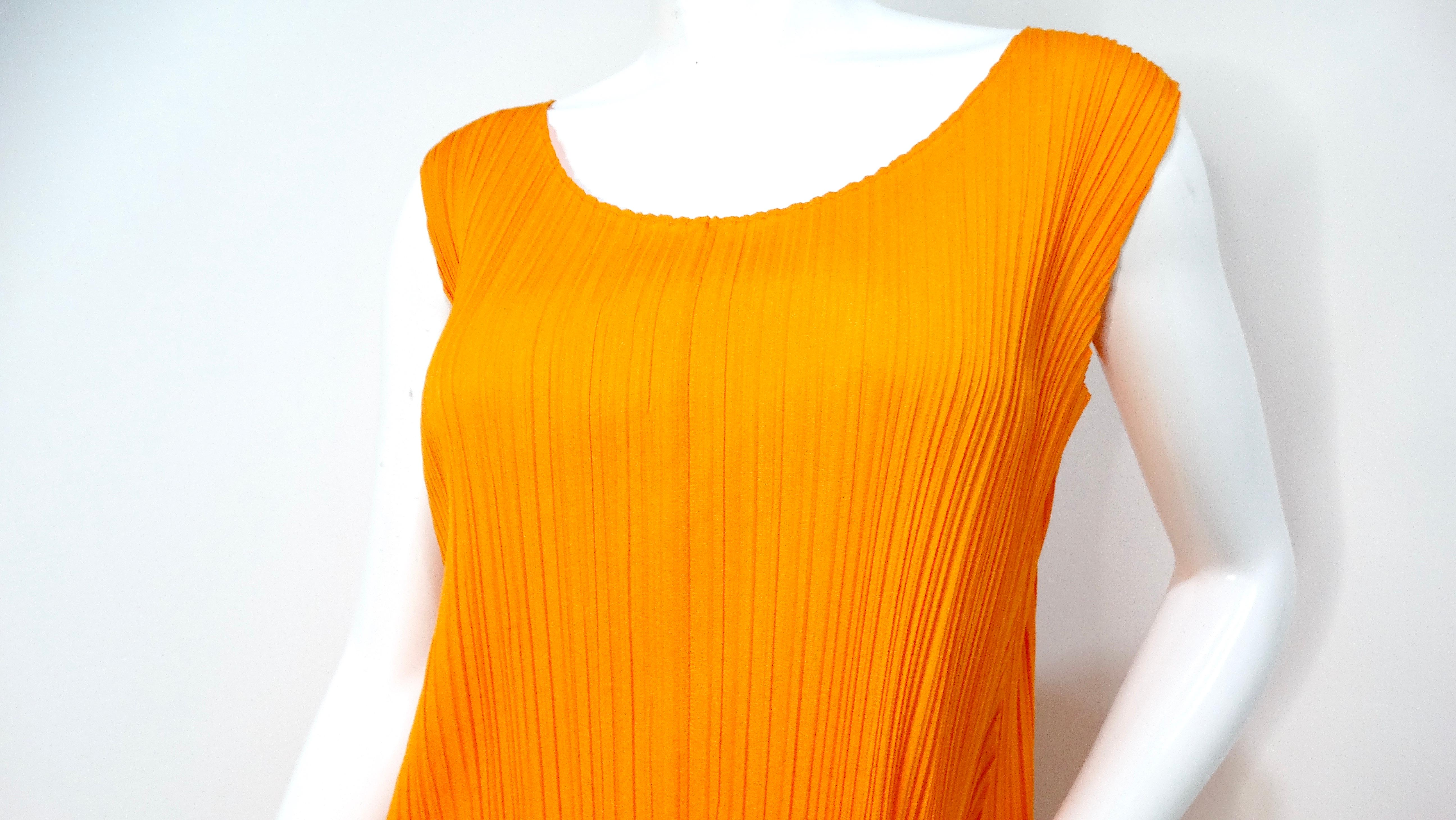 L'abito senza maniche a pieghe arancione Issey Miyake 1990s Pleats Please è un'aggiunta vivace a qualsiasi guardaroba alla moda. Questo abito midi di grande effetto presenta un'audace tonalità tutta arancione che emana energia ed entusiasmo,