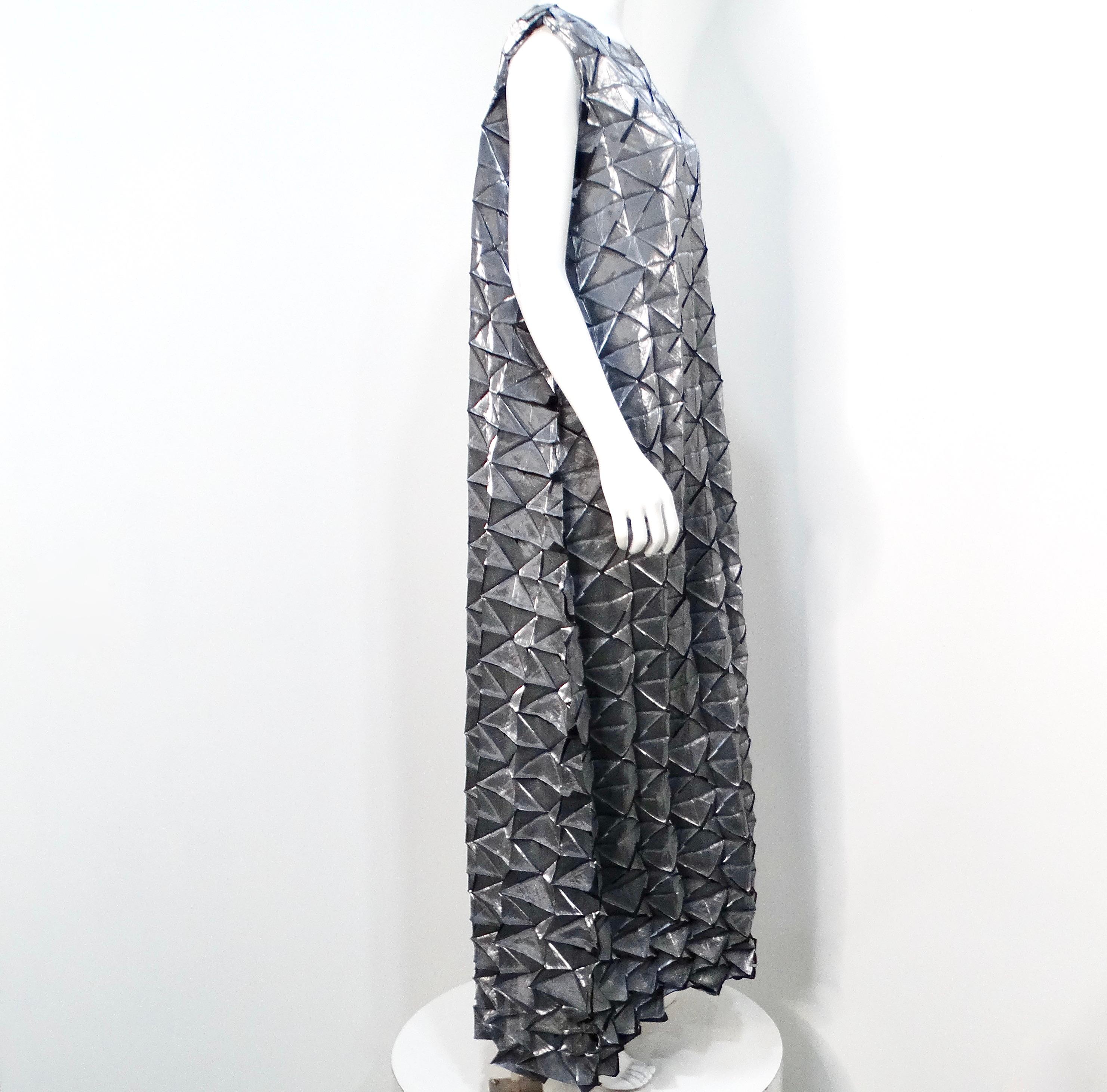 The Issey Miyake 1990s Silver Frost Geometric Pleated Sleeveless Maxi Dress is a stunning statement piece that embodies the innovative spirit of Issey Miyake. This dress features an intricate design of geometric pleated triangles, crafted in a