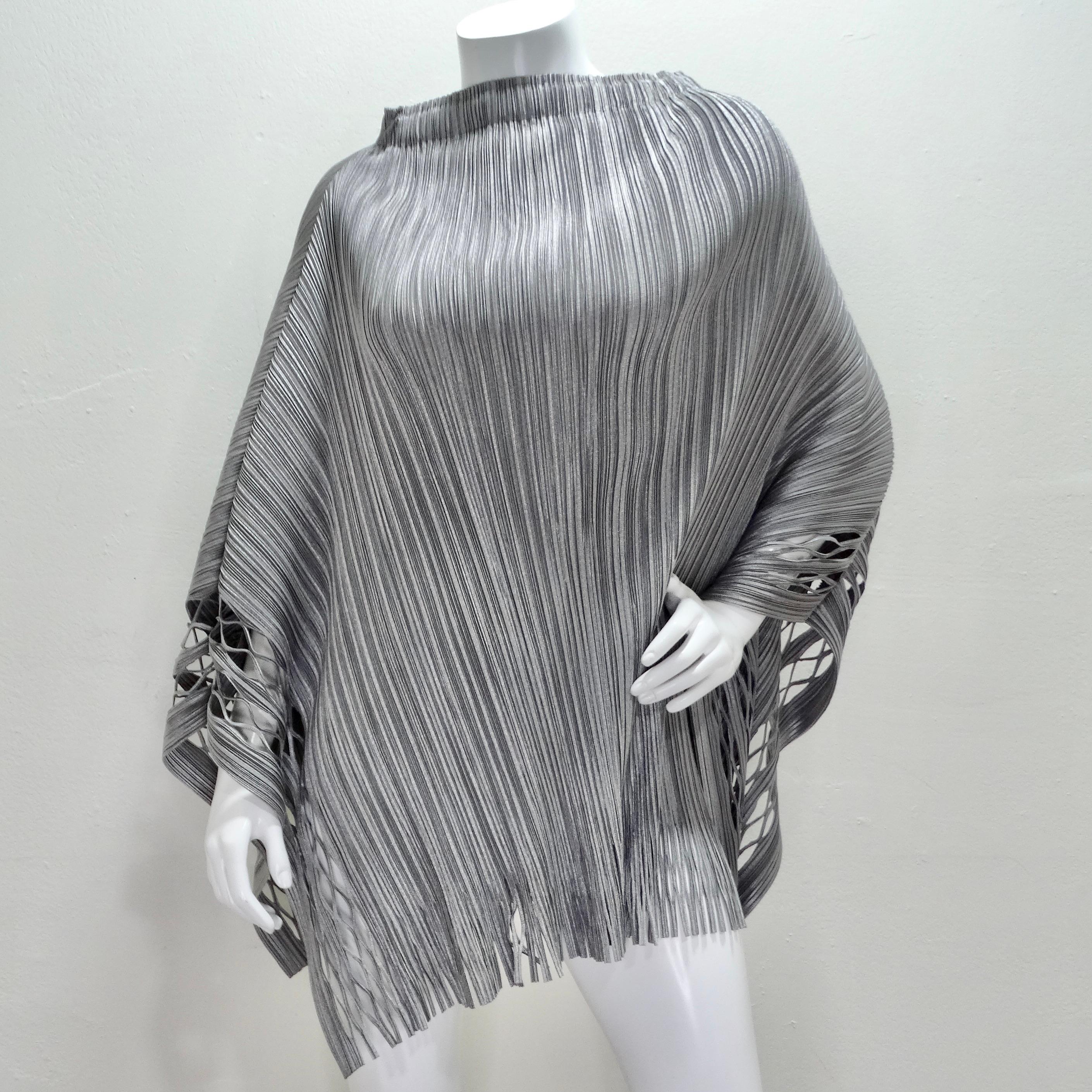 The Issey Miyake 1990s Silver Pleated Poncho is a stunning vintage piece that showcases the designer's innovative use of pleats and textile design. This metallic silver poncho features a pleated turtleneck, which adds a luxurious and sophisticated