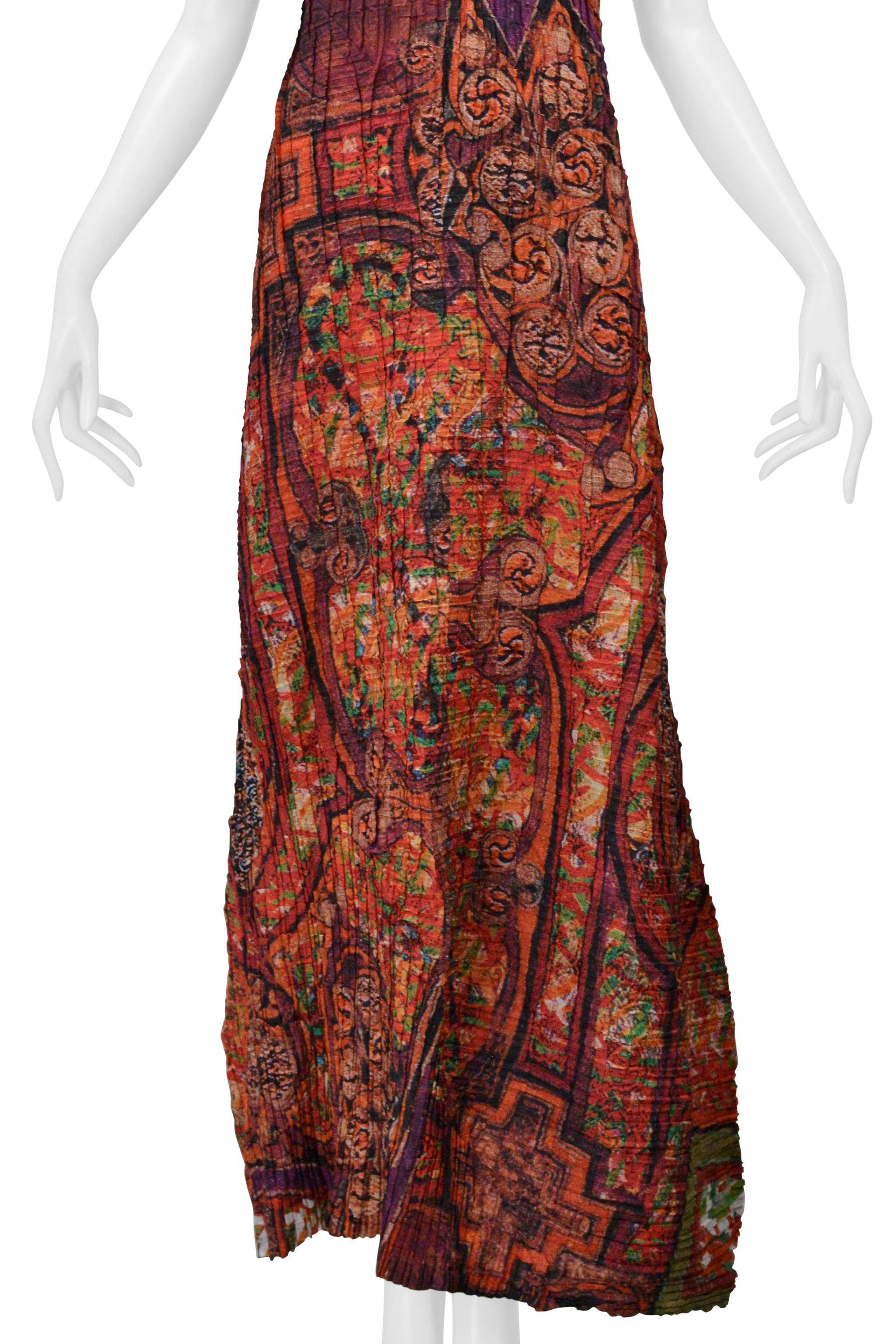 Resurrection Vintage è entusiasta di presentare un maxi abito vintage Issey Miyake bordeaux e Jewell, caratterizzato da una delicata scollatura a V, un corpo fluido e svolazzante, una finitura tutta increspata e un design lungo fino al