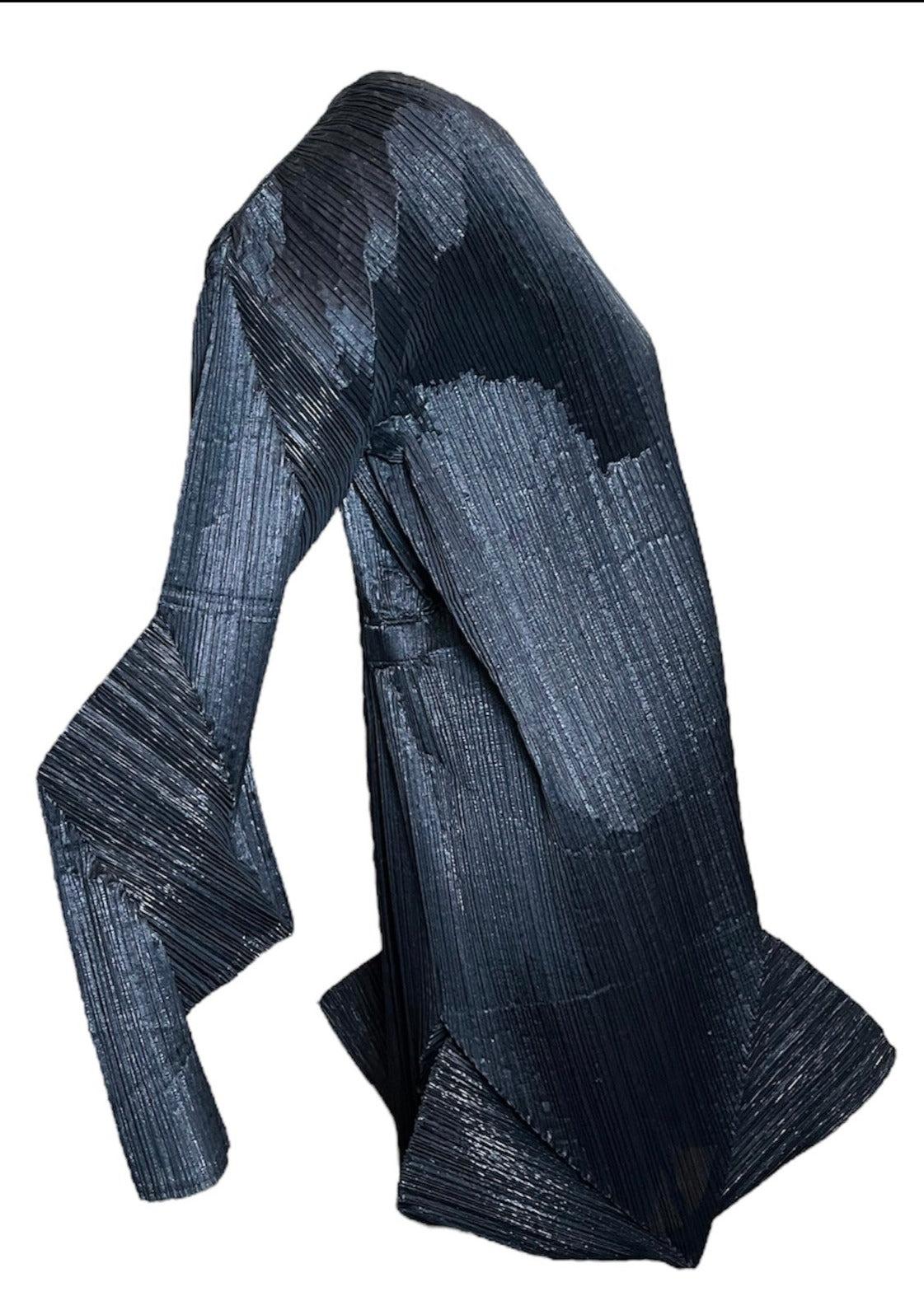 Vestido negro Issey Miyake Otoño Otoño 1994/95 con brillo metálico y pliegues característicos del famoso diseñador. Este minivestido es una mezcla de seda y poliéster con una silueta arquitectónica.  Sin forro y con la espalda fruncida.