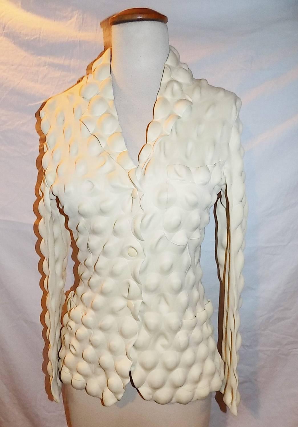 Fabulous  Issey Miyake Egg Carton coat in cream from the Fall / Winter 2000 Collection. 
Features all over rippled bubble imprint, single breasted, three cream snap closures at front, two patch pockets at the hip. Highly sought after and