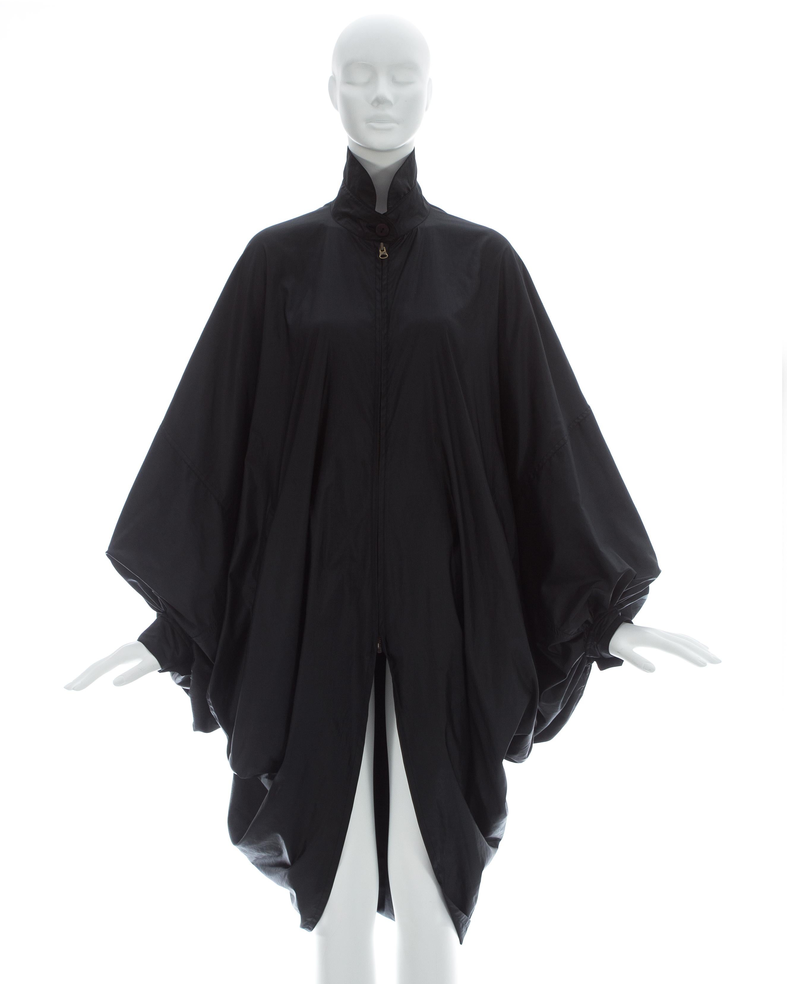Issey Miyake ; manteau noir en nylon parachute surdimensionné, manches chauve-souris et deux poches avant.

Automne-Hiver 1987