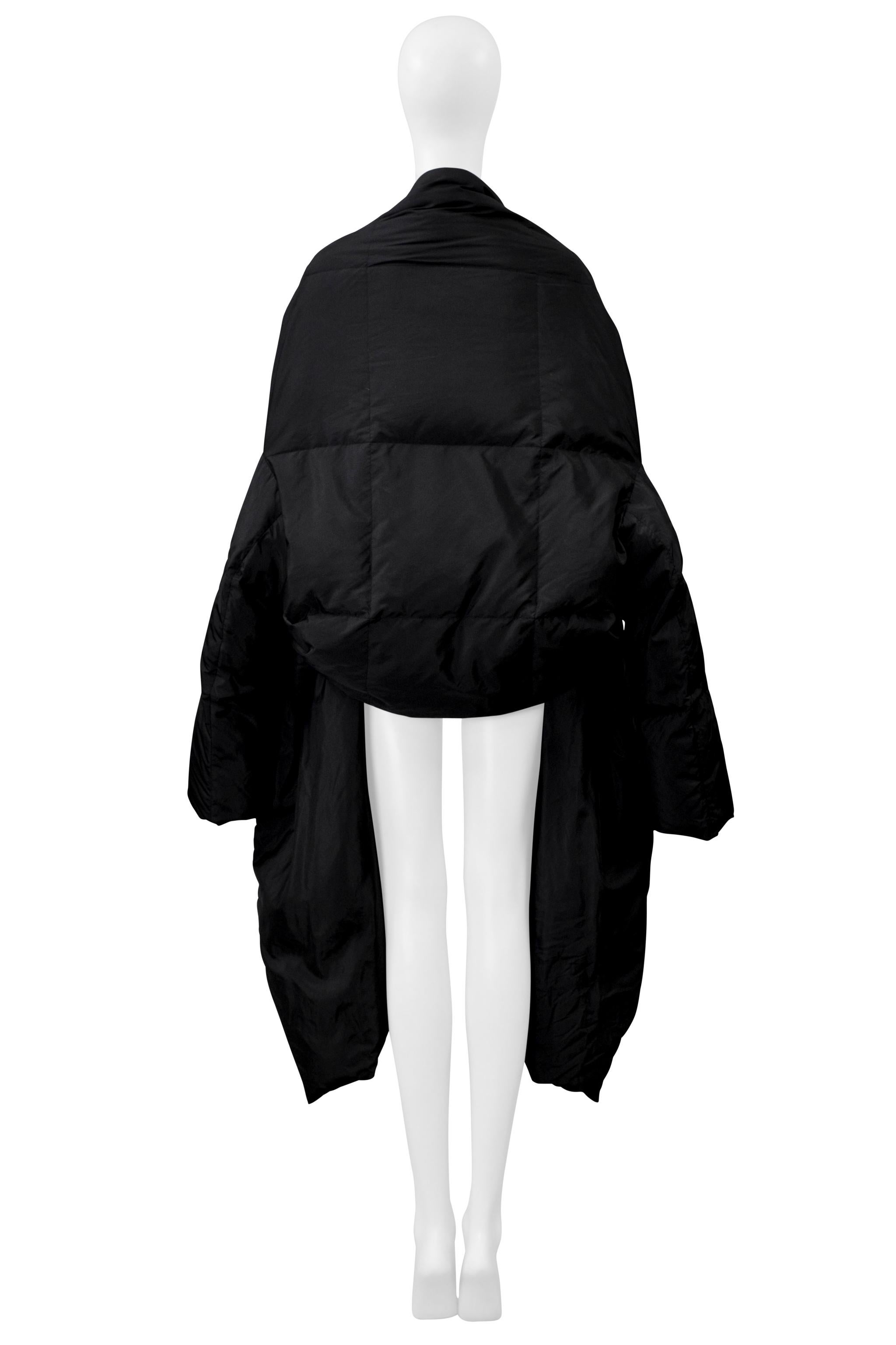 Resurrection Vintage freut sich, eine schwarze, wattierte Issey Miyake Kapuzenjacke aus den Jahren 1999-2000 anbieten zu können. Sie hat einen hochgezogenen Saum, einen hohen Kragen, einen asymmetrischen Frontverschluss und eine übergroße