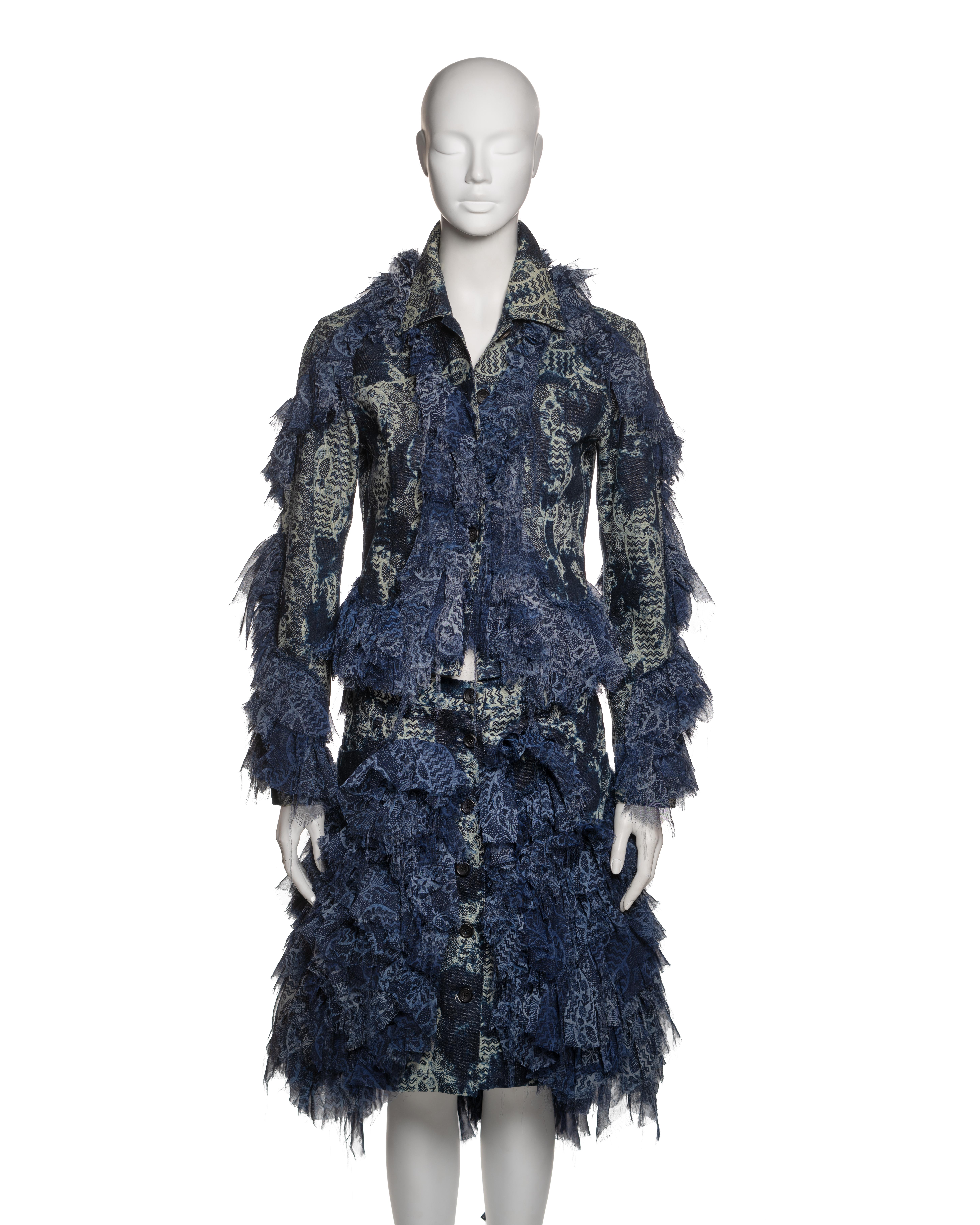 This Issey Miyake ensemble from the Fall-Winter 2003 collection consists of a structured denim jacket and matching skirt, both featuring an intricate layered construction with printed chiffon ruffles. The indigo denim base is printed with an