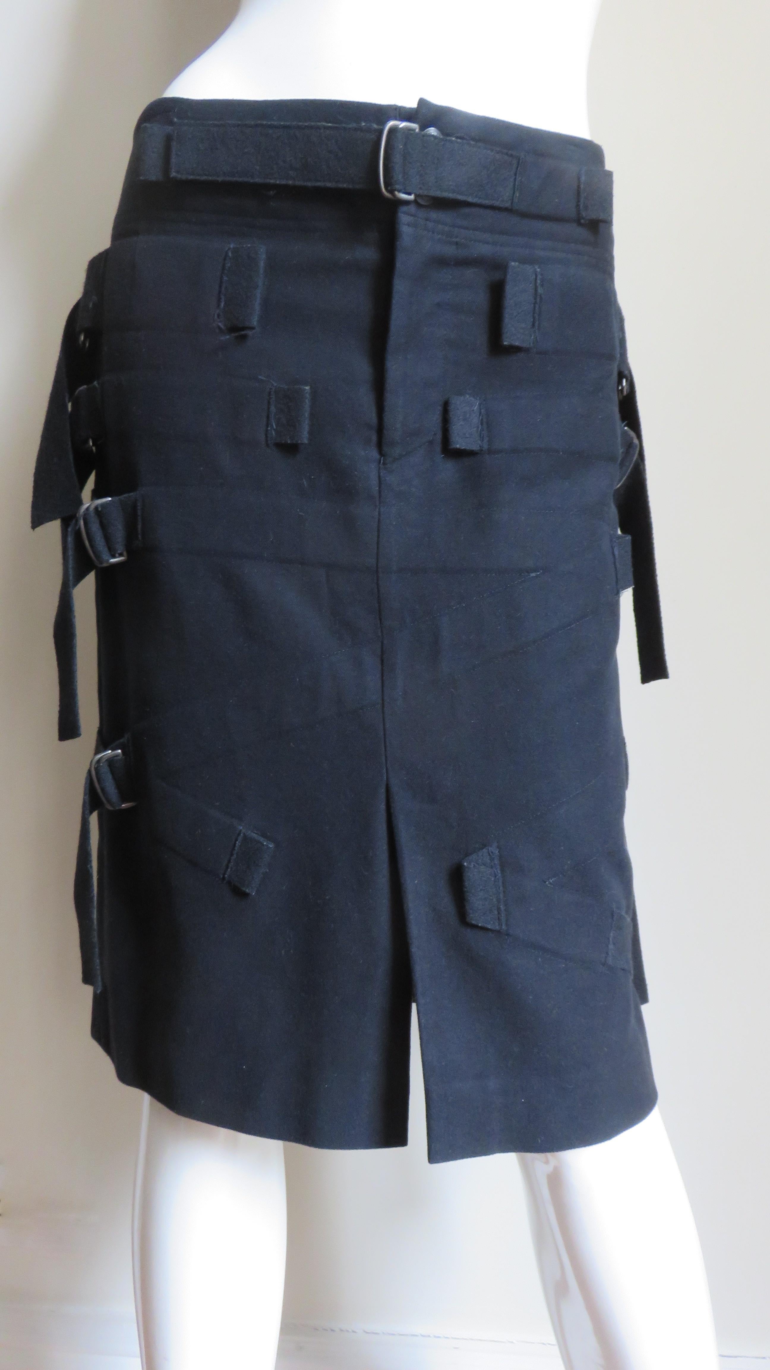 Une fabuleuse jupe en coton mélangé noir de Issey Miyake. La jupe droite est dotée de bretelles fonctionnelles et réglables et d'anneaux métalliques de chaque côté. Il est doublé, doté d'une fermeture à glissière sur le devant et de deux boutons en