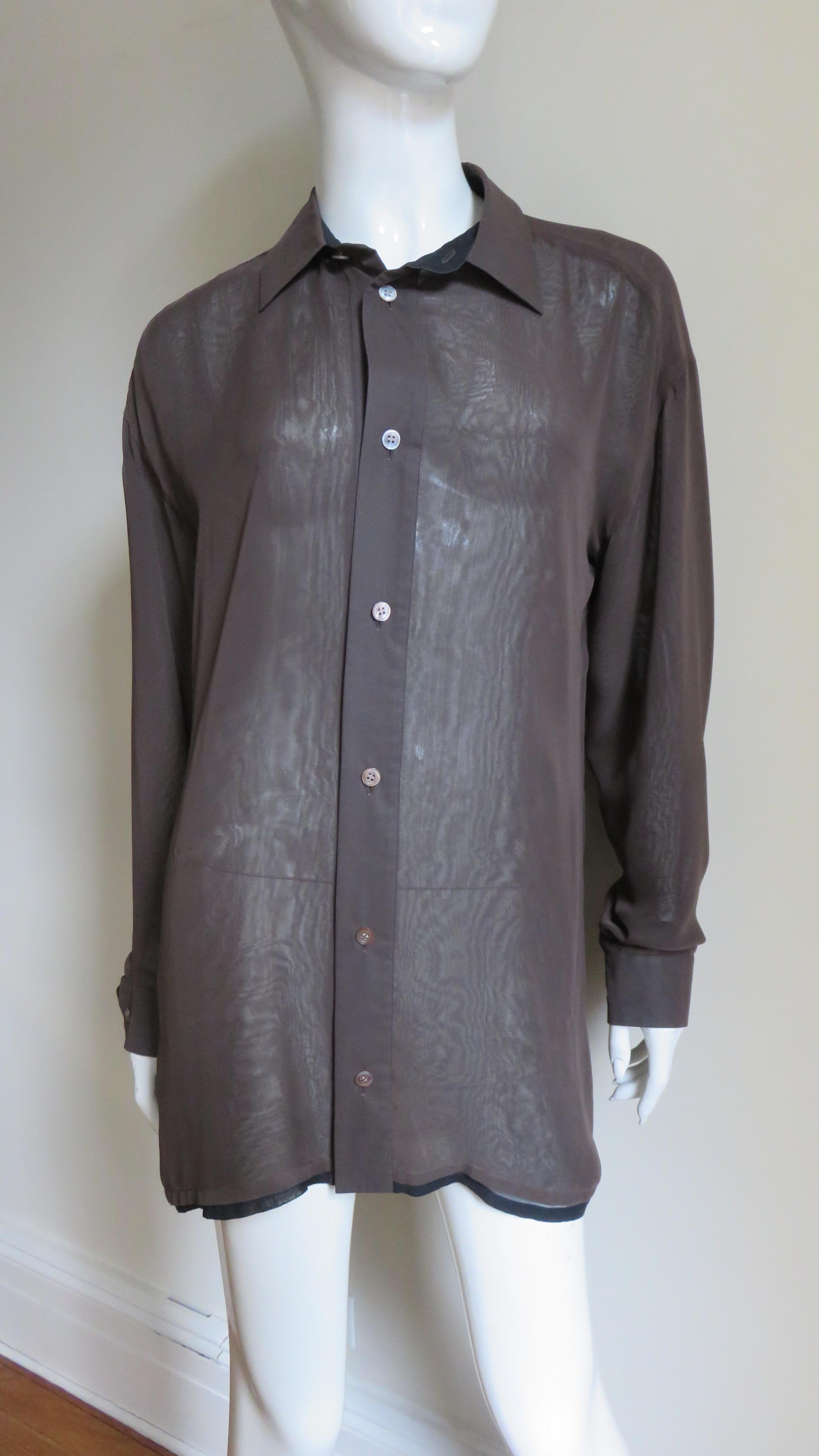 Ein fabelhaftes 2-lagiges Hemd von Issey Miyake.  Es besteht aus 2 halbdurchsichtigen Schichten, einer schwarzen Schicht und einer braunen Schicht darüber, wobei die schwarze Schicht am Saum herausschaut.  Es hat einen Hemdkragen, eine Rückenpasse