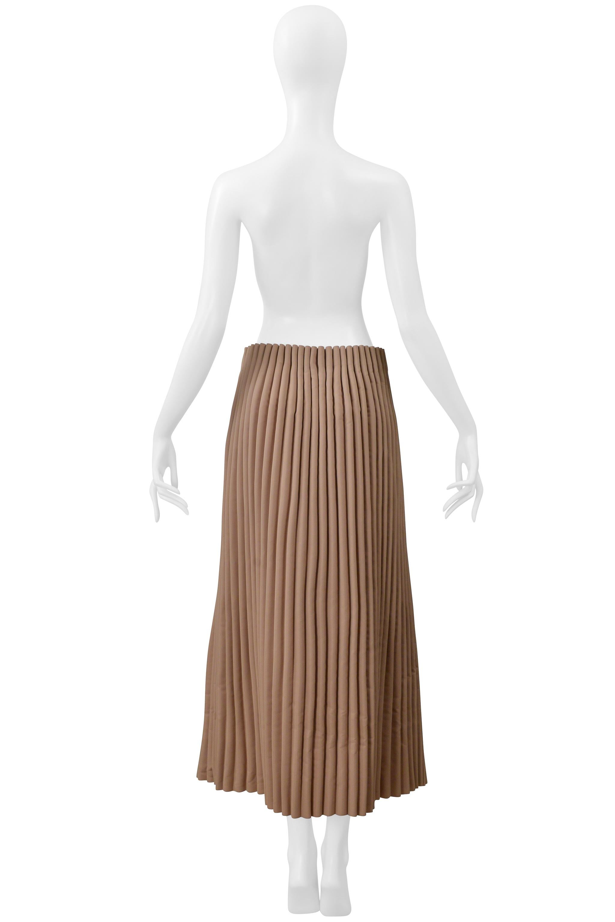 Resurrection Vintage è lieta di presentarti una gonna lunga vintage di Issey Miyake marrone con pieghe a fisarmonica della collezione anni 2000, caratterizzata da una silhouette dritta, cerniera con chiusura a gancio e lunghezza alla