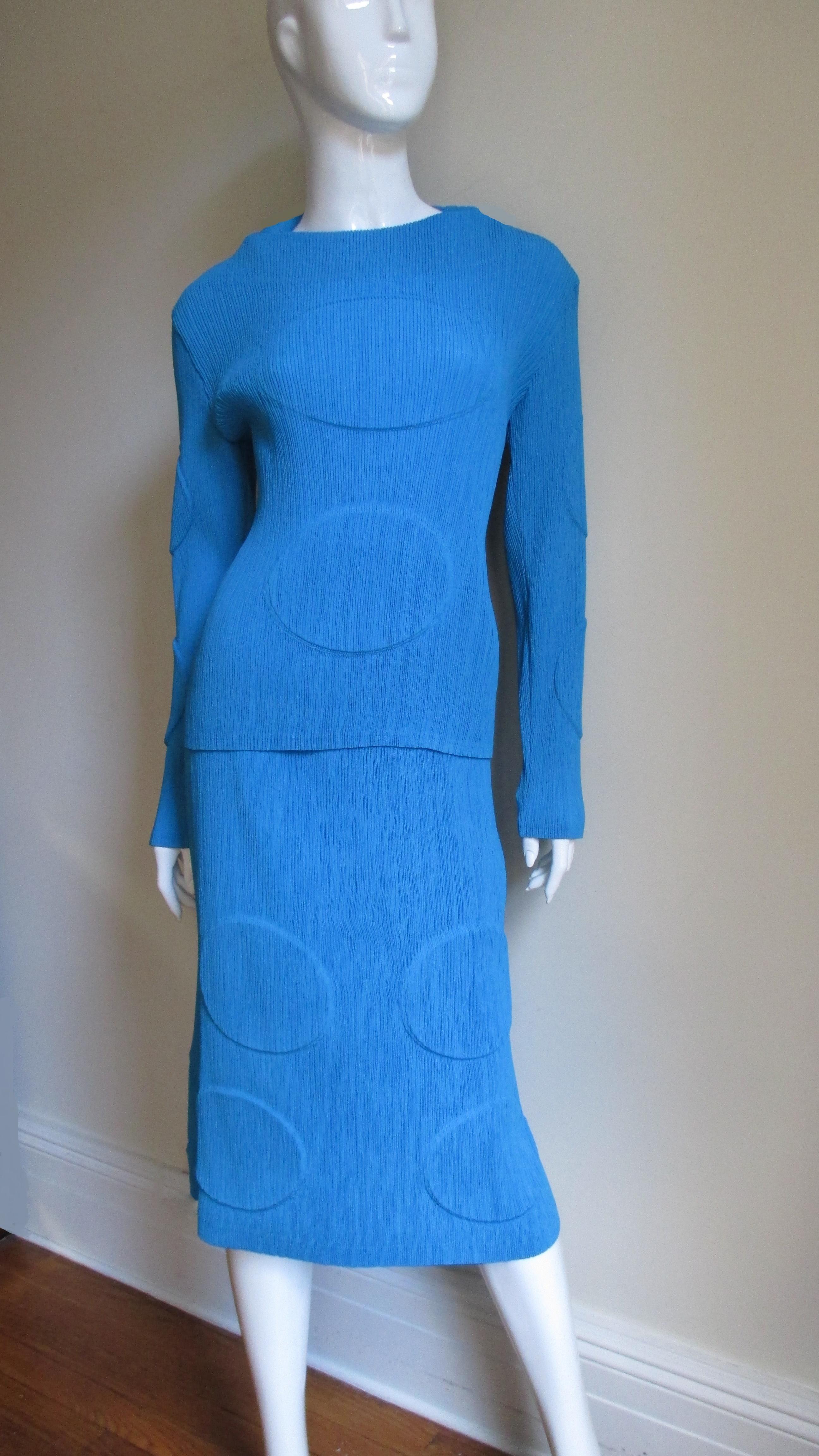 A fabulous 2 piece set from Issey Miyake in beautiful blue micro pleating the designer is famous for.  The long sleeve top has a bateau neckline and the skirt is straight with a stretch waist.  Both pieces have large orb imprints- convex on the