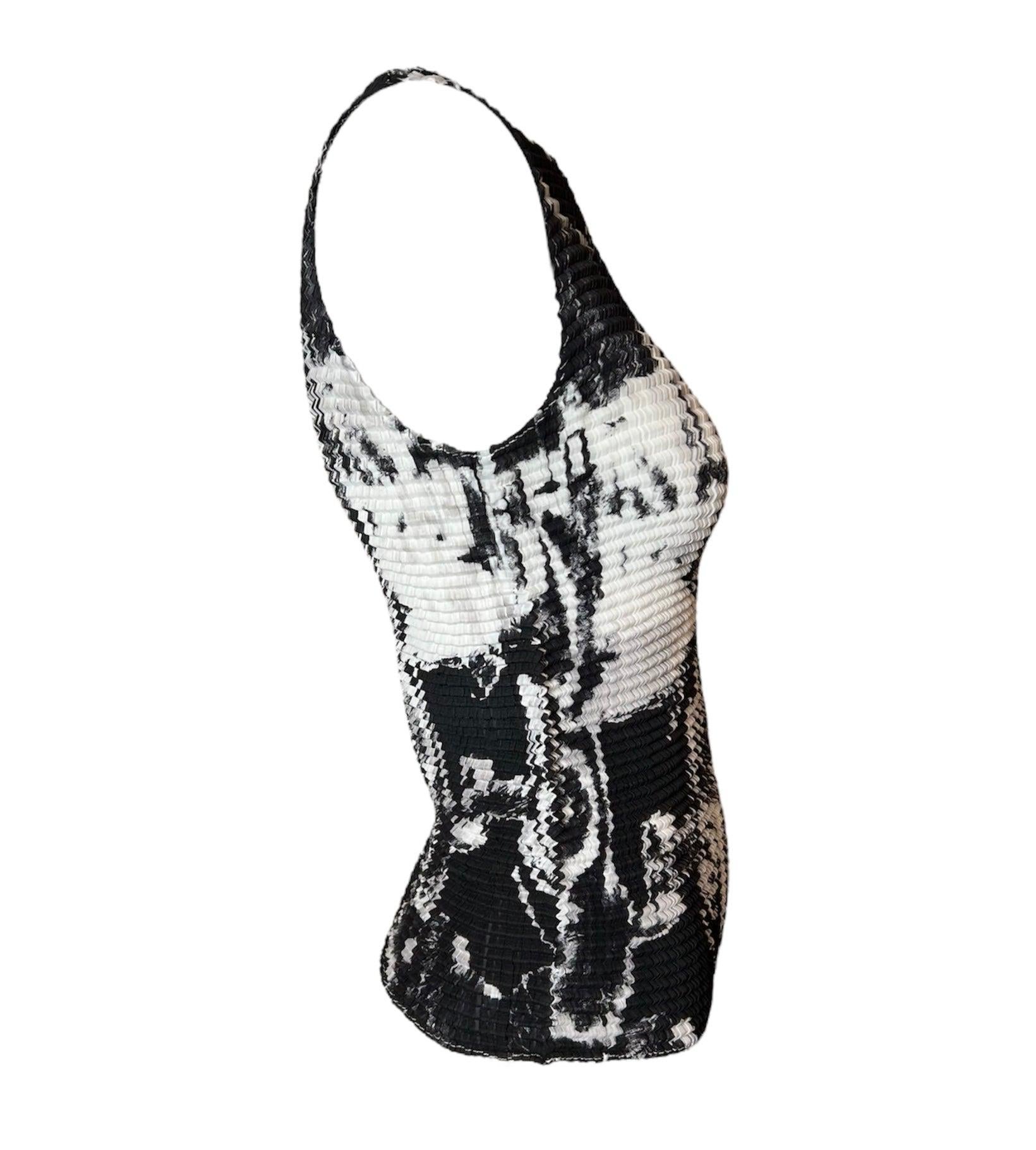 Este flashback de los años 2000 a las icónicas camisas arrugadas de los 90 es un ganador. Nos encanta el diseño abstracto en blanco y negro y su guiño al streetwear: recuerda mucho a los tops pintados a mano de la escena punk de los 80. Este top