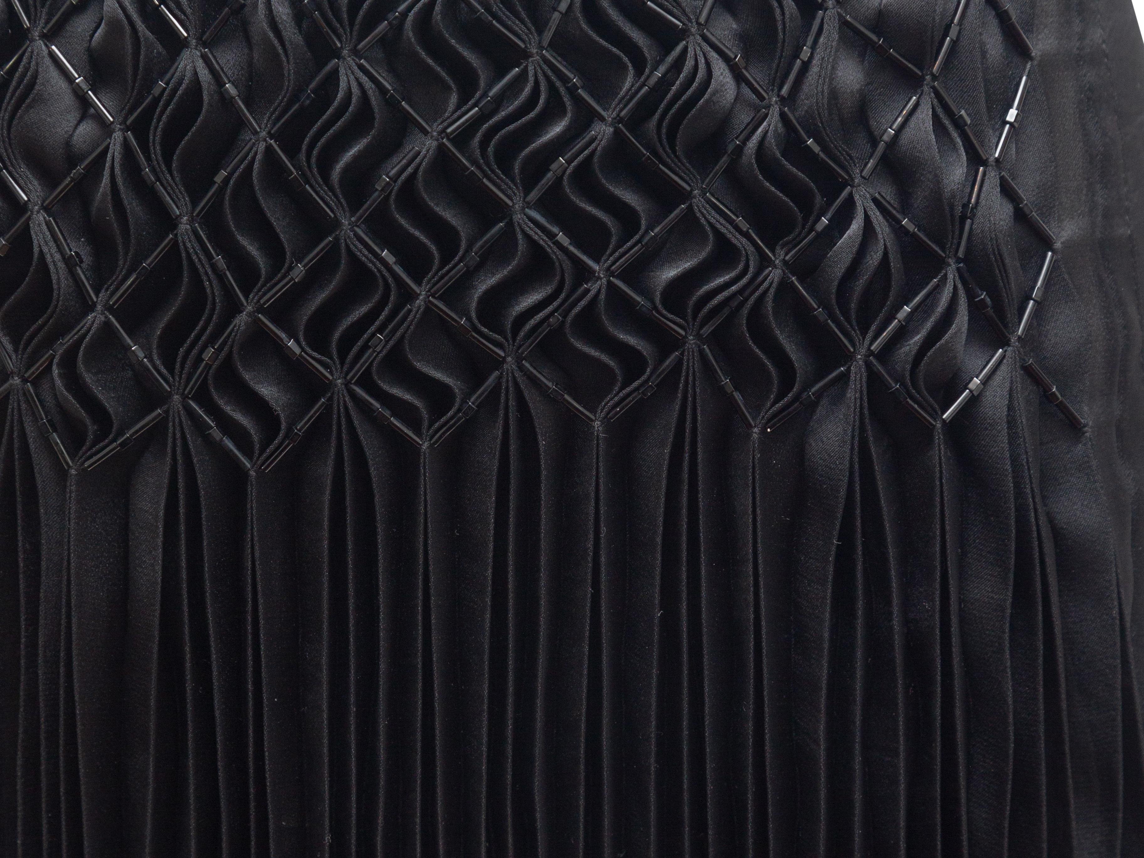 Product details: Black pleated skirt by Issey Miyake Fete. Tonal bead accents at pleats. 31