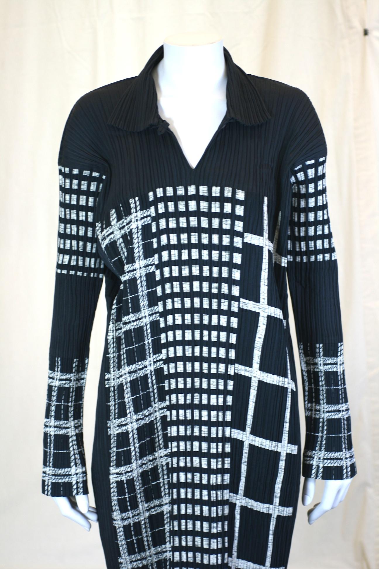 Issey Miyake Graphic Black White Dress in signature pleats. The various patterns look like a night time cityscape. Pullover style with open slash collar with long, lean silhouette.
Size Small. Length 50