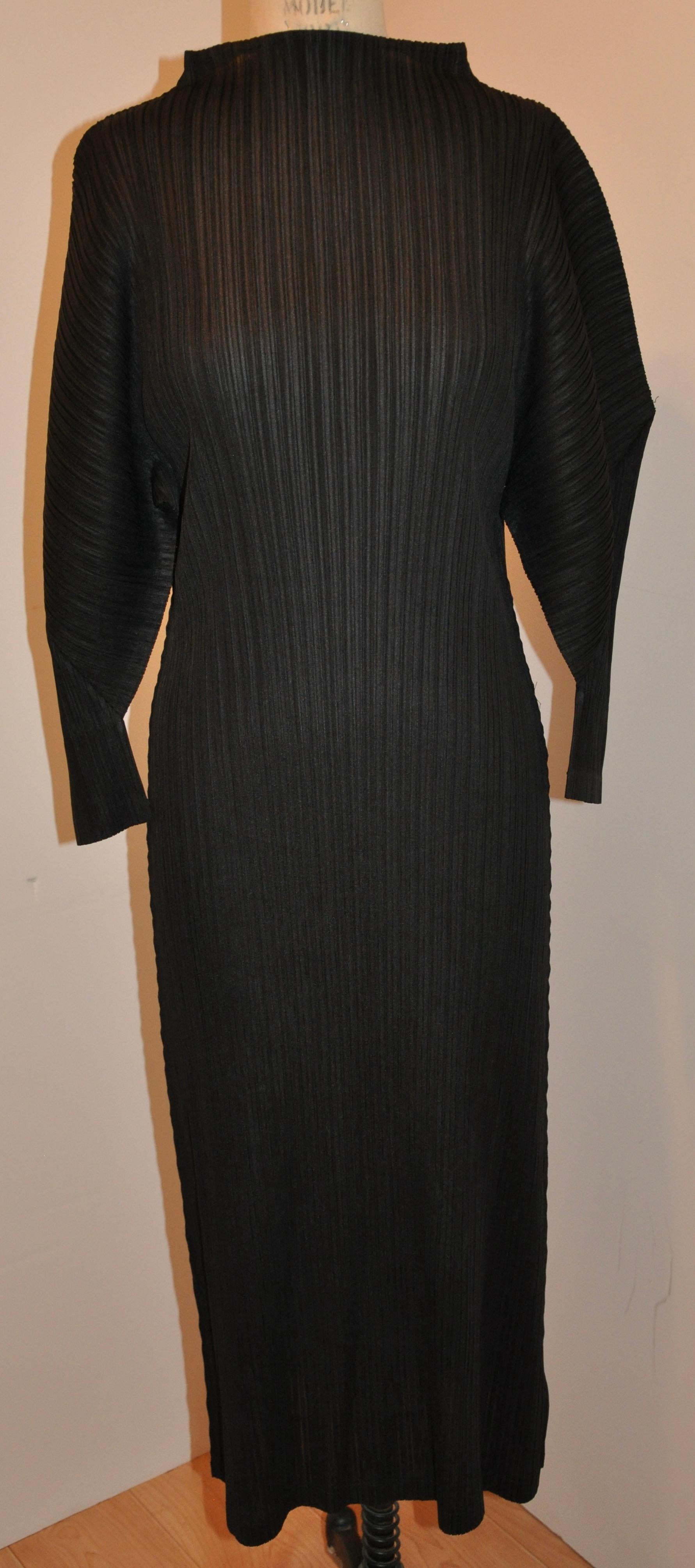      Issey Miyake iconic signature jet-black high-neck , slightly flared pullover dress measures 47 1/2 inches in length. Neckline circumference is 18 inches, shoulders are 25 inches across, sleeves are 13 inches in length, cuffs are 8 inches,