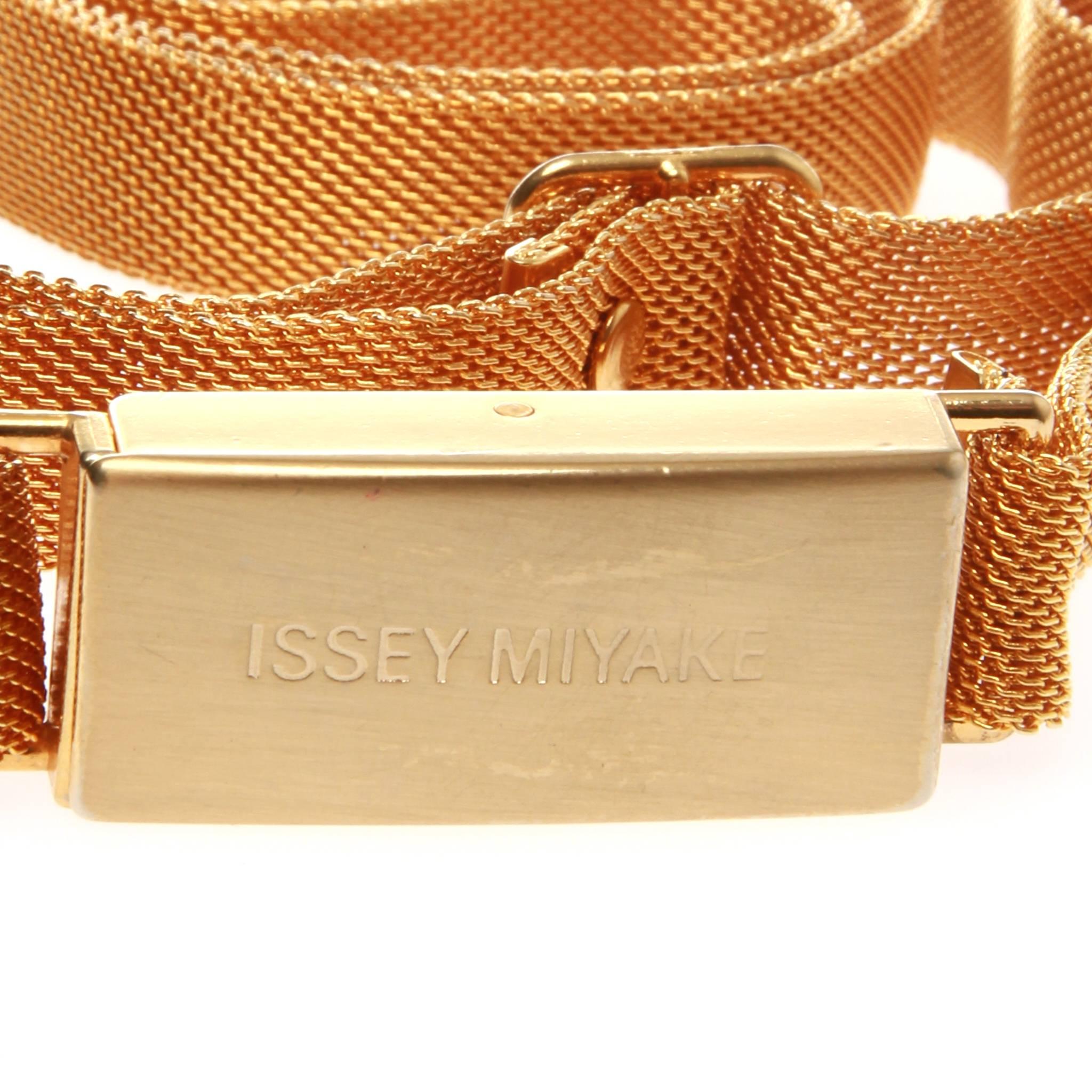 Issey Miyake with a gold mesh strap and gold brand engraved rectangular clasp. Adjustable. 