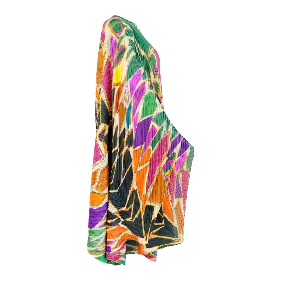 Cette remarquable robe kaftan à cape asymétrique Pleats Please d'Issey Miyake présente un imprimé mosaïque vibrant dans un spectre de couleurs audacieuses, des verts luxuriants aux oranges ardents en passant par les violets riches. Fabrice dans le
