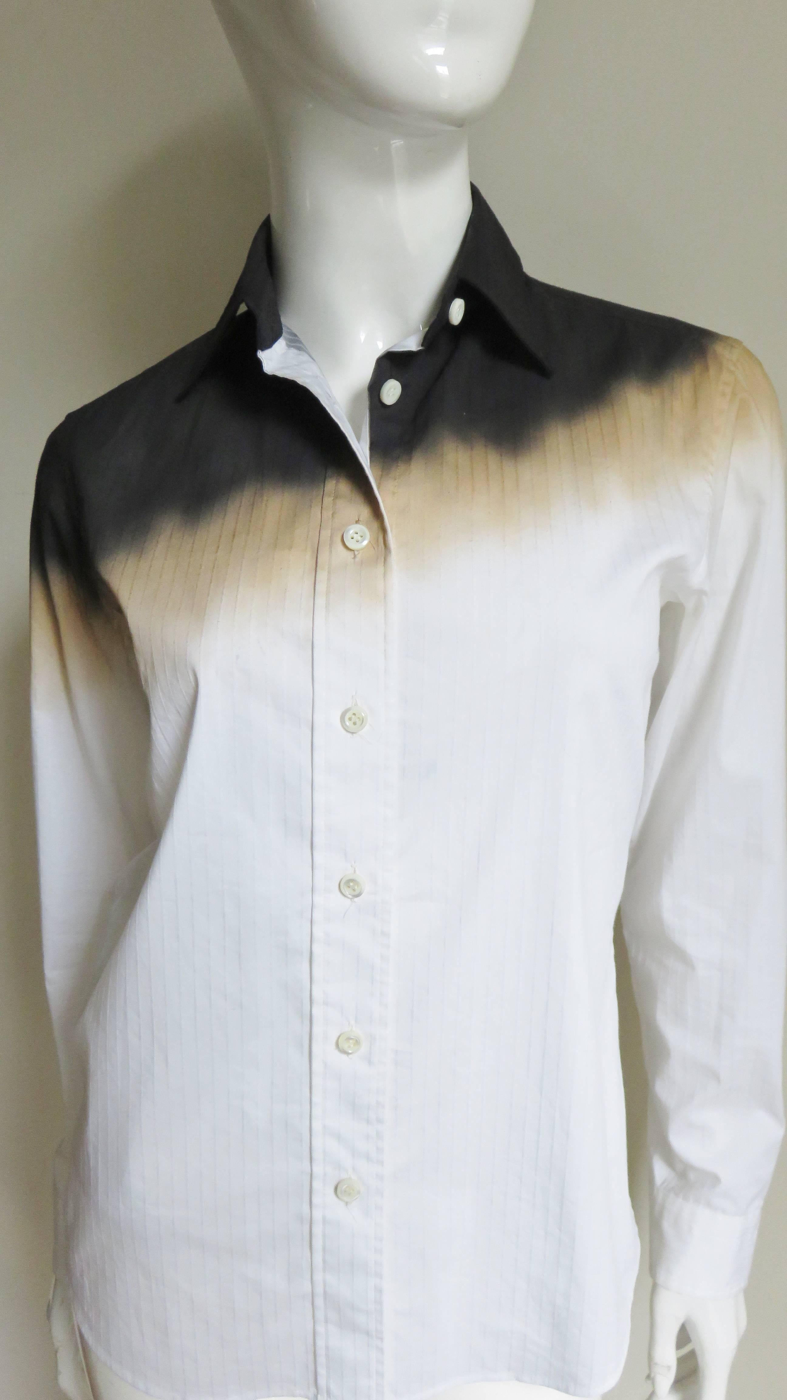 A great off white cotton shirt by Issey Miyake.  It has a diagonal ombre pattern across the shoulders blending from black to gold.  The shirt has long sleeves, mother of pearl  button cuffs and front plus a shirt tail hem.
Fits sizes Small,