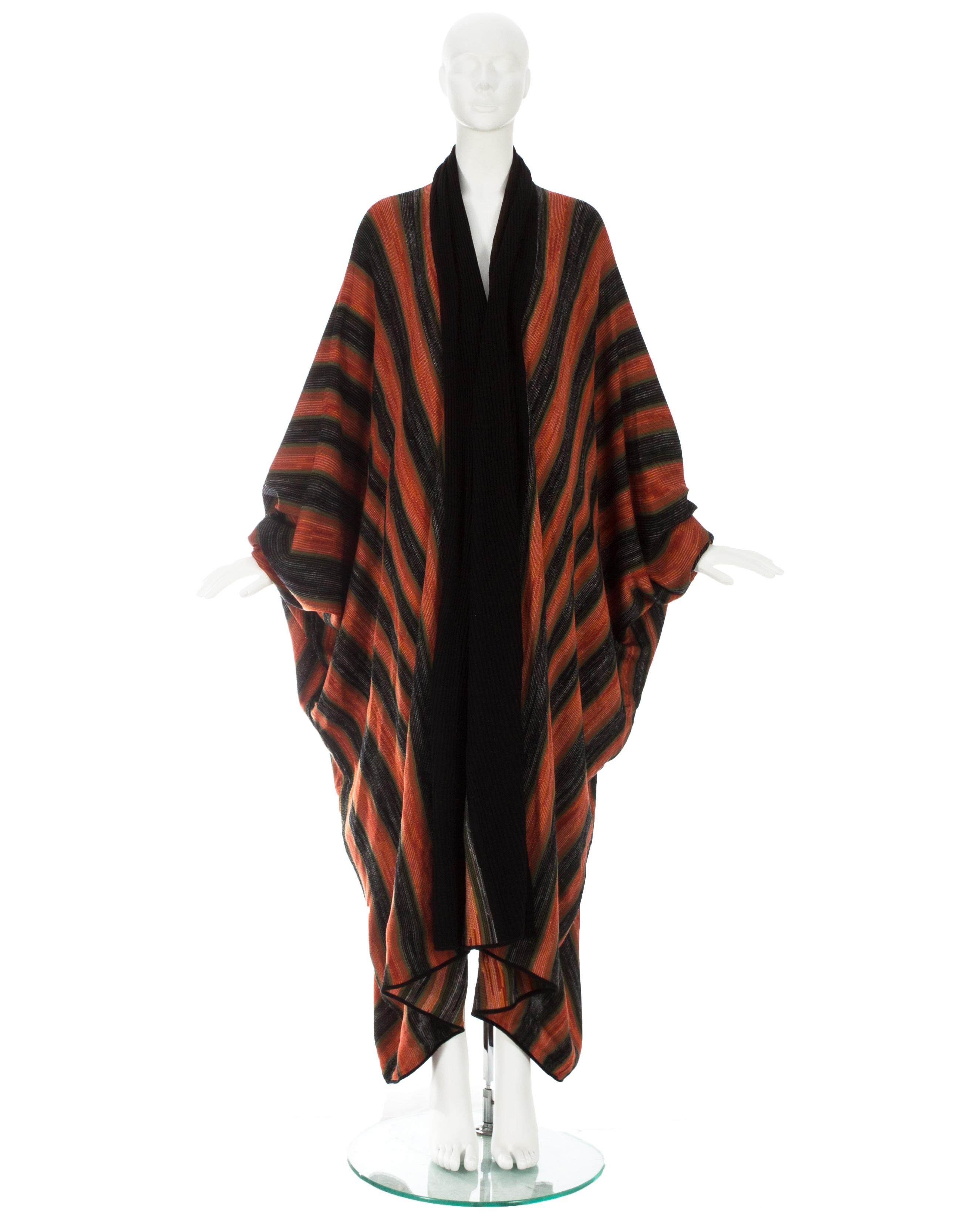 Issey Miyake; Orange acetate knit batwing robe with black rib-knit cuffs and shawl collar 

Fall-Winter 1976