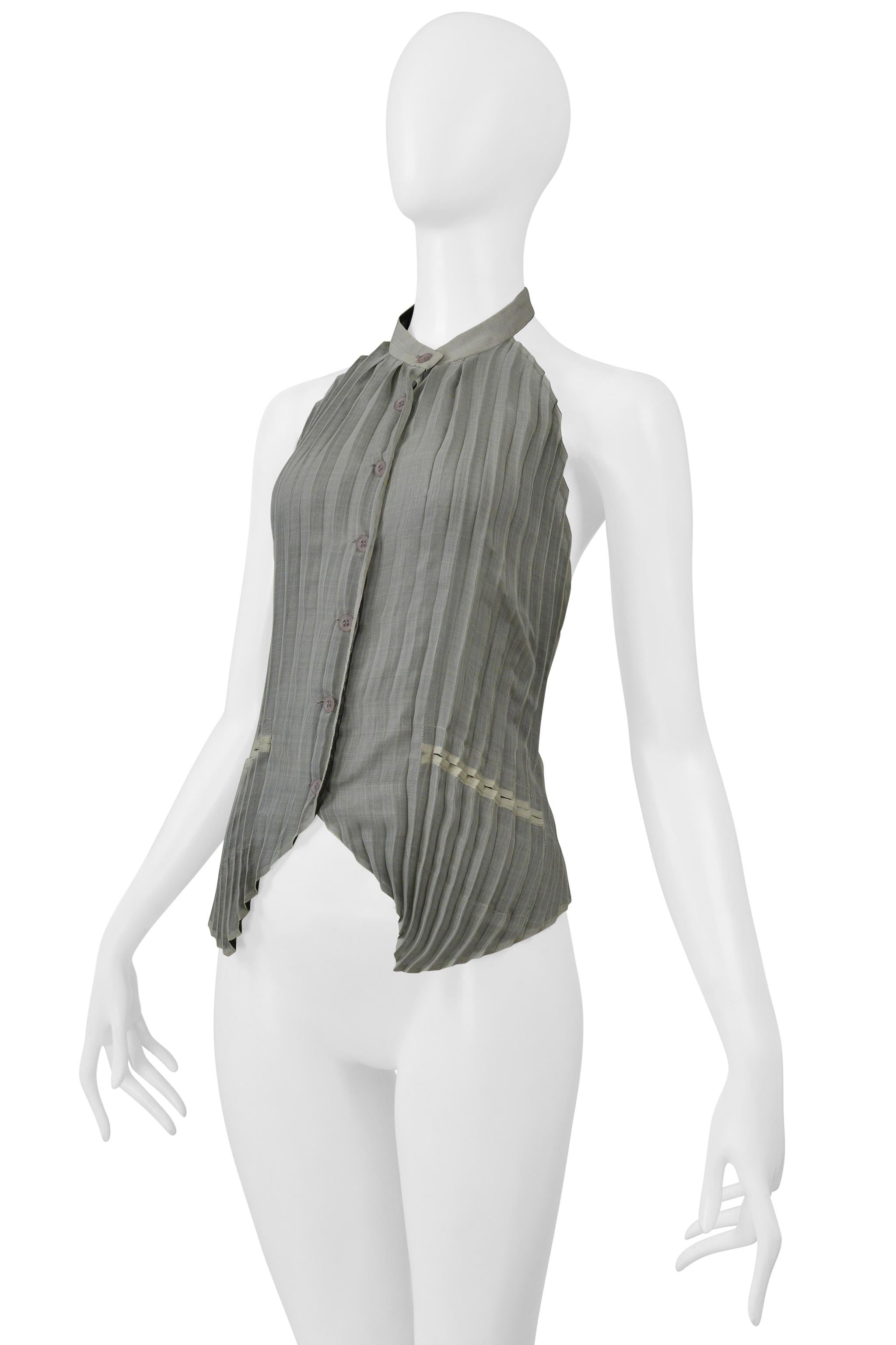 Resurrection Vintage è lieta di offrirti un top vintage Issey Miyake grigio perla con colletto a collo alto, chiusura con bottoni al centro, schiena scoperta, tasche finte e fibbia regolabile sul retro. 

Issey Miyake
Dimensioni: Media 
Tessuto: