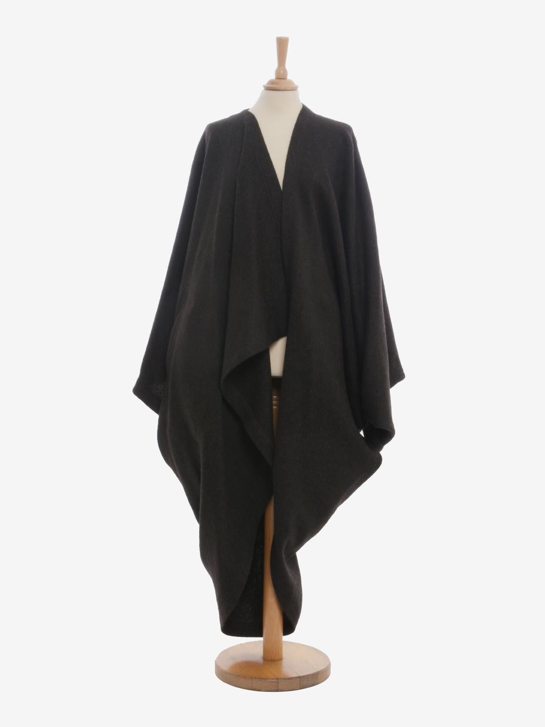 Der Issey Miyake Wool Dolman Coat ist ein Kleidungsstück aus der 1985 eingeführten Permanente-Kollektion, die für die Wiederbelebung der ursprünglichen Formen und Stoffe aus früheren Issey Miyake-Kollektionen bekannt ist. Die Oberbekleidung zeichnet