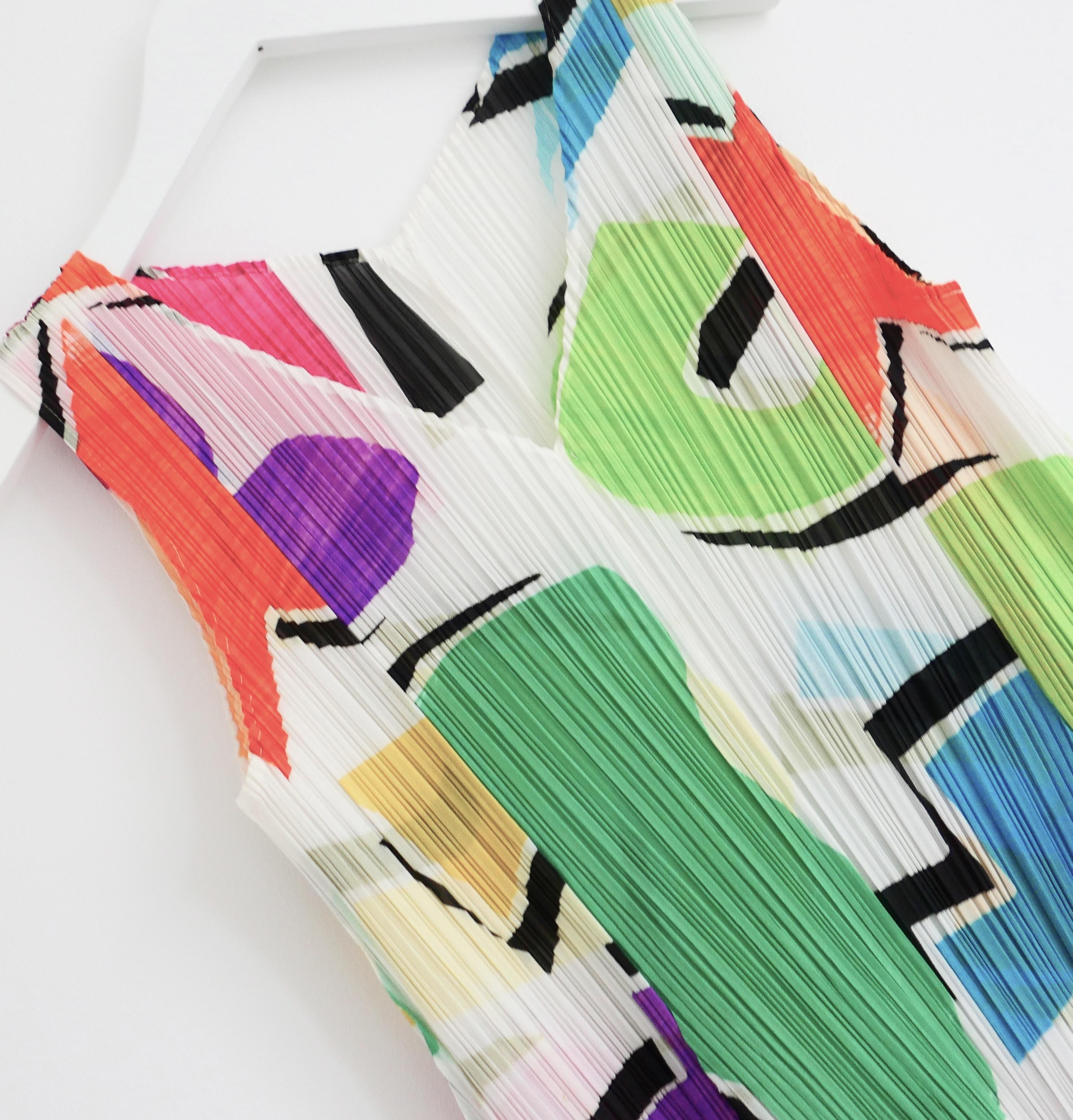 Wunderschönes Issey Miyake Pleats Please Kleid mit Farbblockdruck. Ungetragen. Es ist aus dem charakteristischen plissierten Polyester mit einem leuchtenden abstrakten Druck gefertigt und hat einen ausgestellten Schnitt mit V-Ausschnitt. Code des