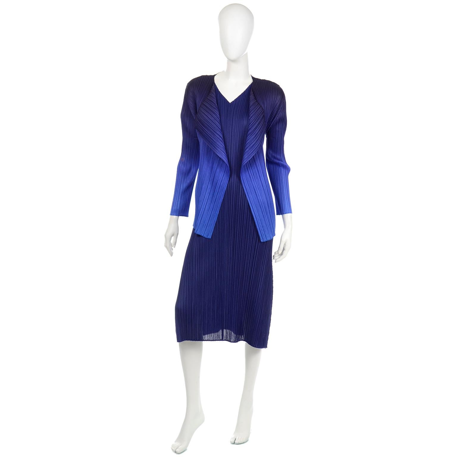 This is a sensational Issey Miyake Pleats Please indigo blue dress and ombré jacket ensemble. This stunning dress has a v-neck front with cinched shoulders that are completely adjustable by a knotted robe. The sleeves are slightly pointed at the