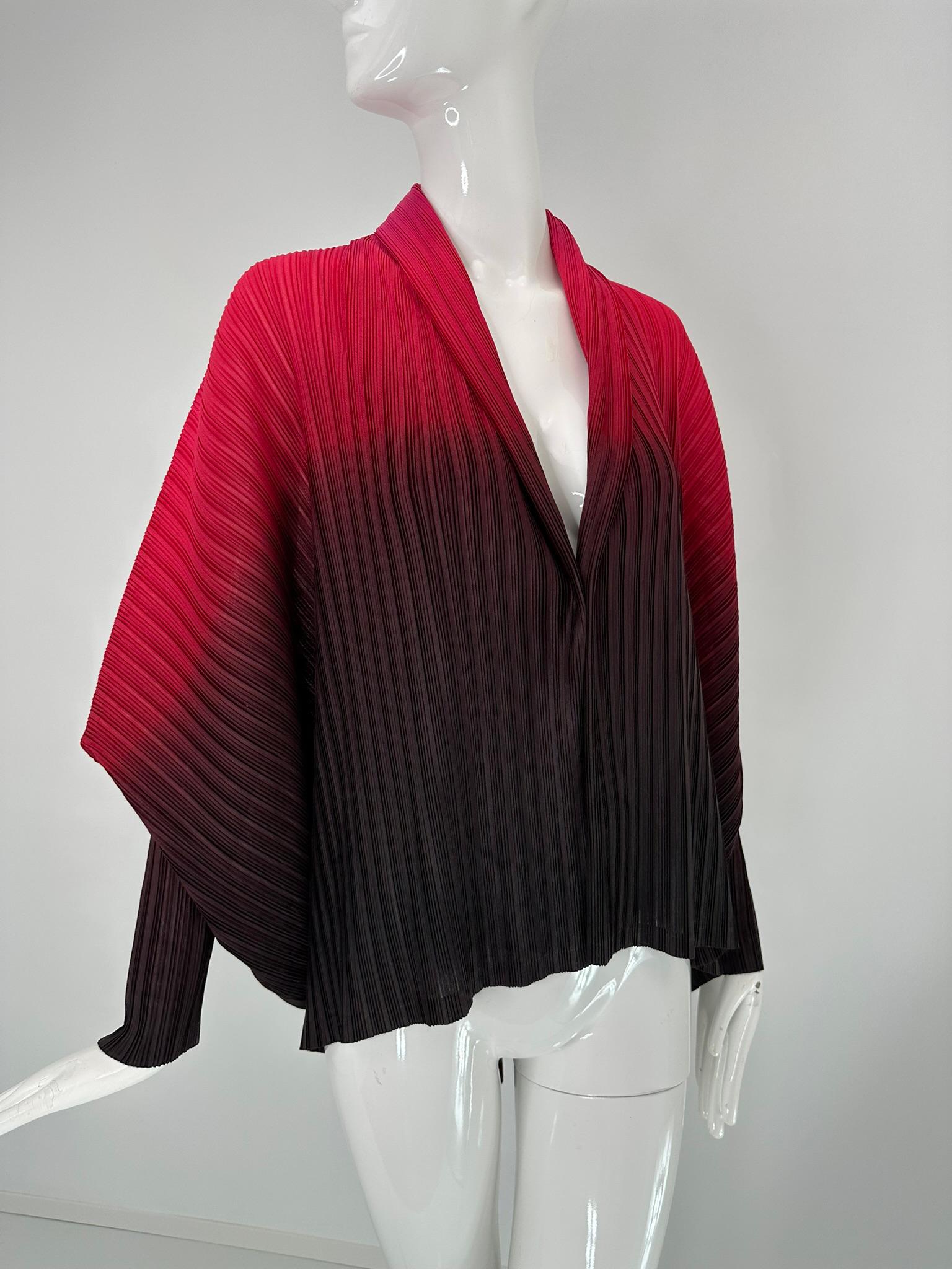 Issey Miyake Pleats Please Chaqueta con cuello chal, puños estrechos y alas de murciélago de ombre rojo a negro. Chaqueta abierta por delante con mangas de ala de murciélago y puños largos y estrechos que permiten una bonita caída. La chaqueta es
