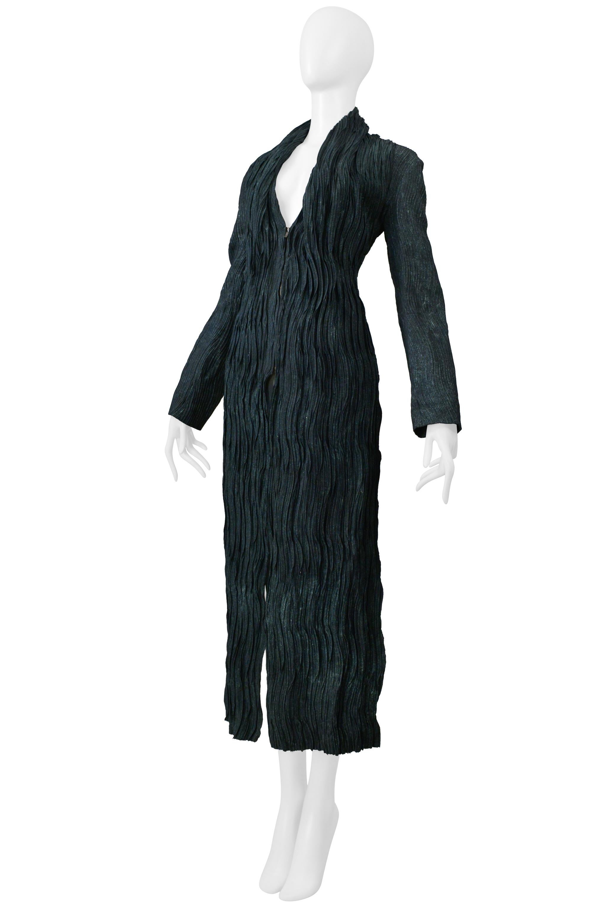 Resurrection Vintage è entusiasta di offrire una giacca vintage a pieghe grigio-verde Issey Miyake della collezione 2002 che presenta un orlo alto-basso, pieghe verticali, cerniera anteriore, scollo a V e cerniere laterali. 

Issey
