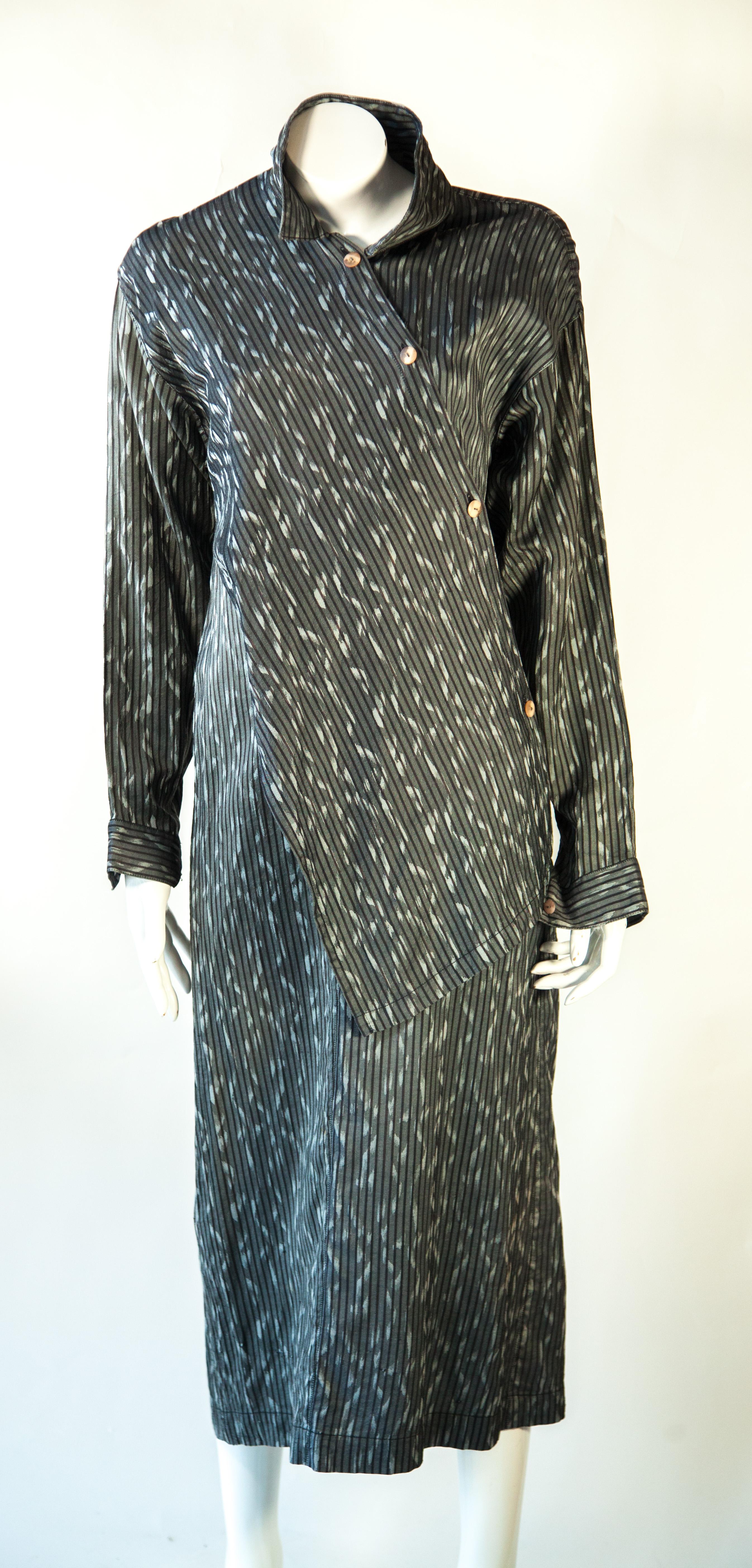 Cette robe uniforme Issey Miyake est conçue pour faire une déclaration. Confectionné en coton rayé gris doux, il présente des manches longues et une coupe en biais pour une silhouette flatteuse. Le tissu léger offre respirabilité et confort, ce qui