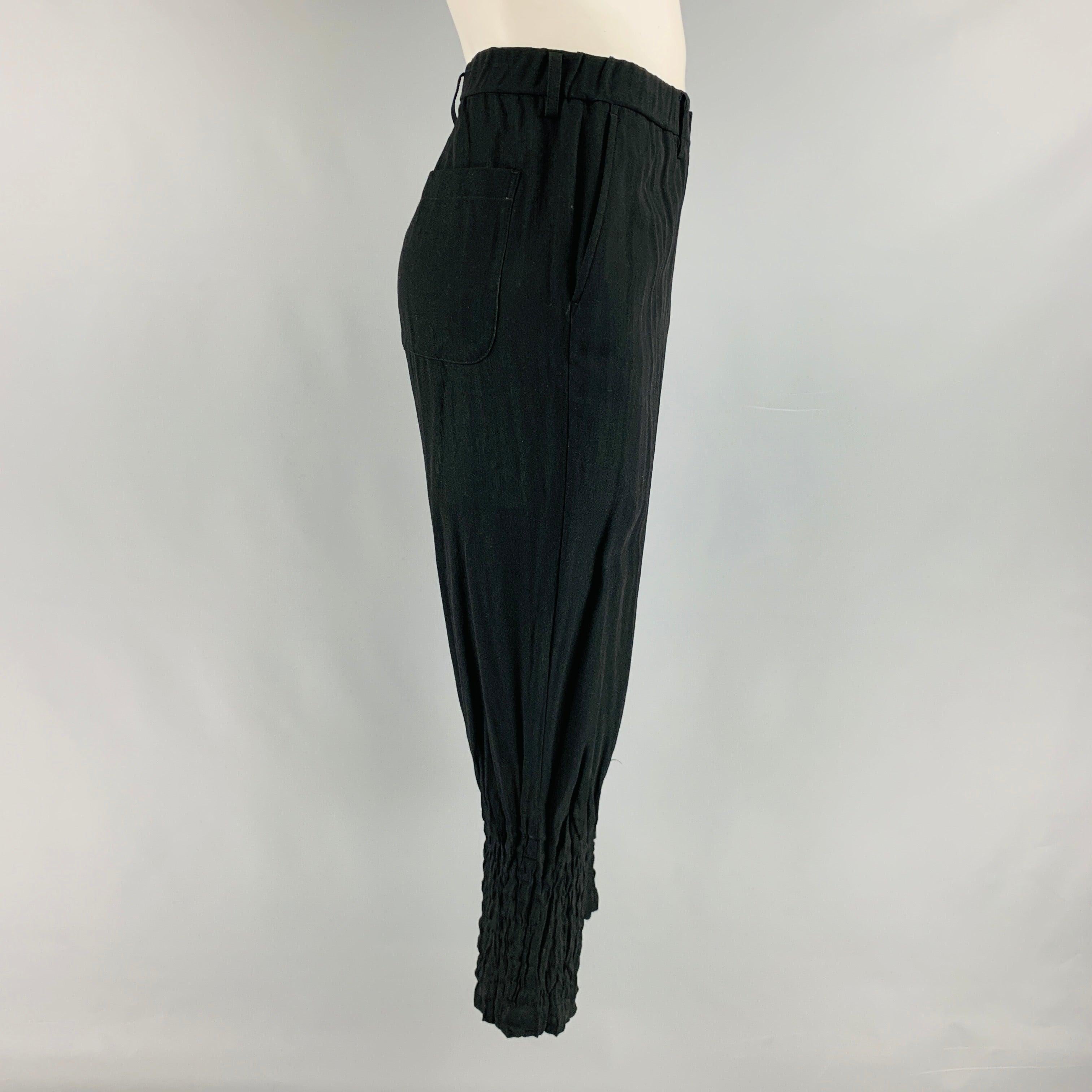 ISSEY MIYAKE casual pants comes in a black woven with a green in lining featuring a tapered ankle, straight leg, slit pockets, elastic at waistband, and a zip fly closure. Made in Japan.Excellent Pre-Owned Condition.  

Marked:   3 

Measurements: 
