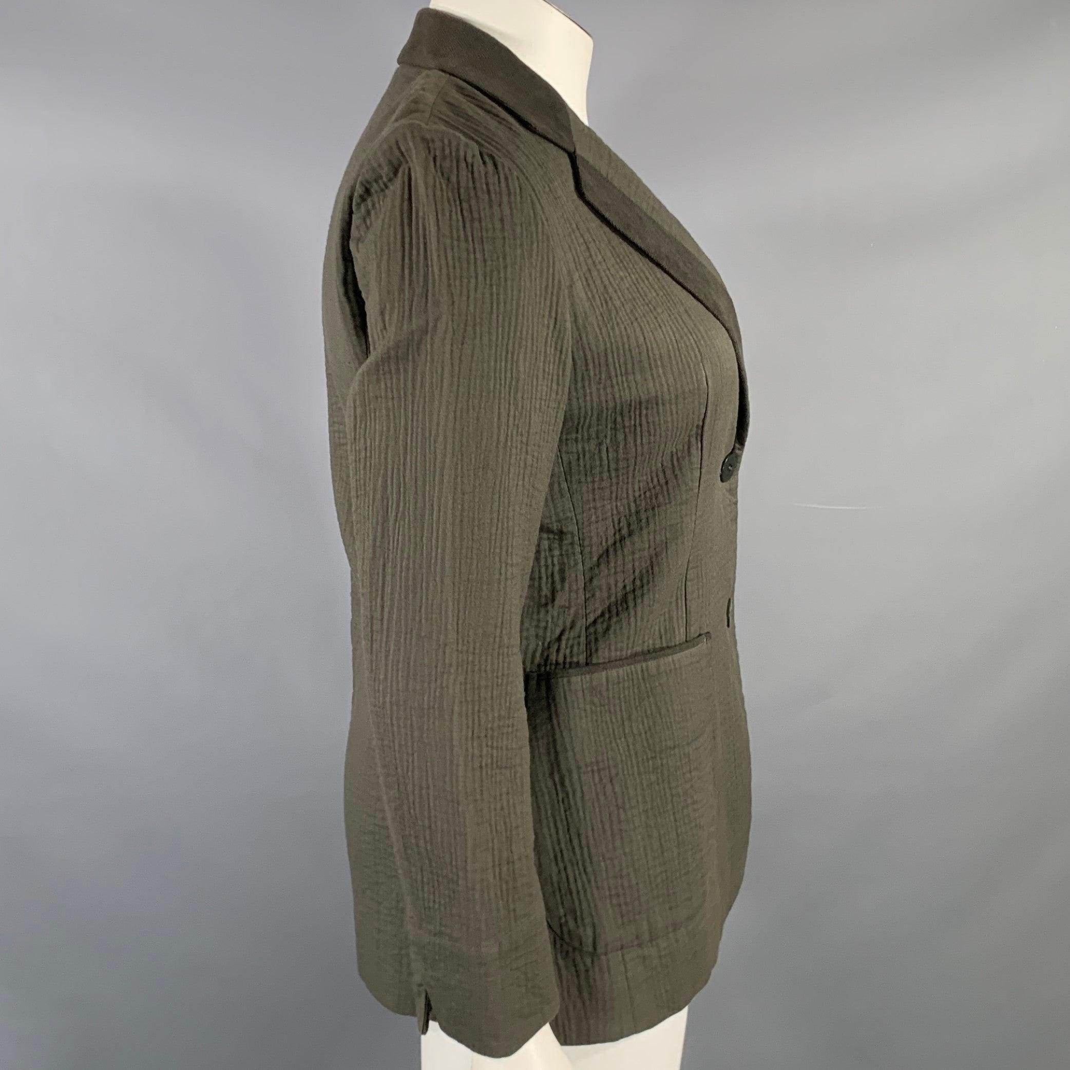 ISSEY MIYAKE jacket in an olive green cotton fabric featuring a textured design, notch lapel with corduroy trim, and double button closure. Made in Japan.Very Good Pre-Owned Condition. Minor signs of wear. 

Marked:   JP 3 

Measurements: 
